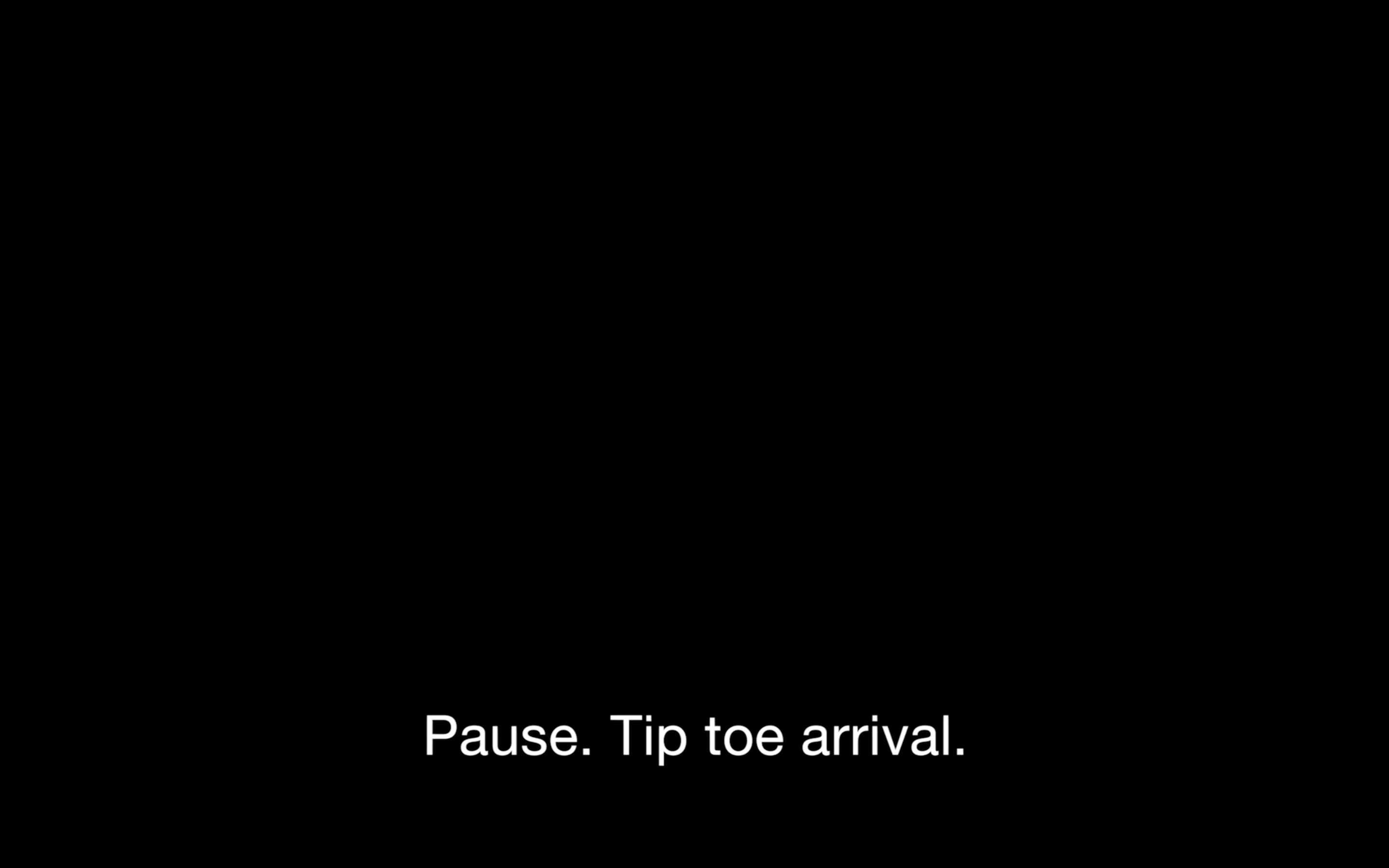 A pitch black background. Centered in the bottom third of the image are white captions that read, "Pause. Tip toe arrival".