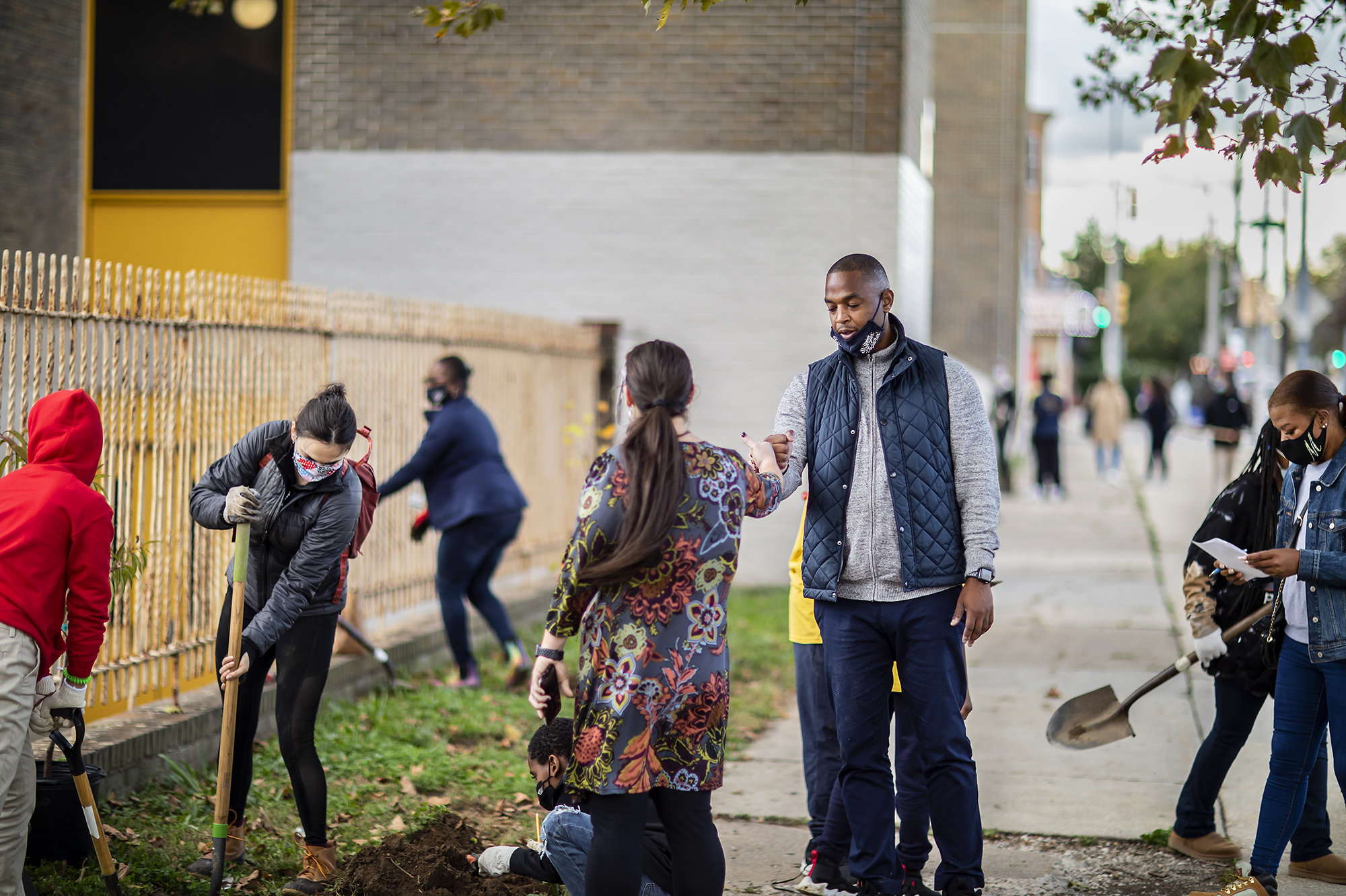 Hamilton principal Torrence Rothmiller bumbs fists with a teacher while students dig in the garden outside of Hamilton school.