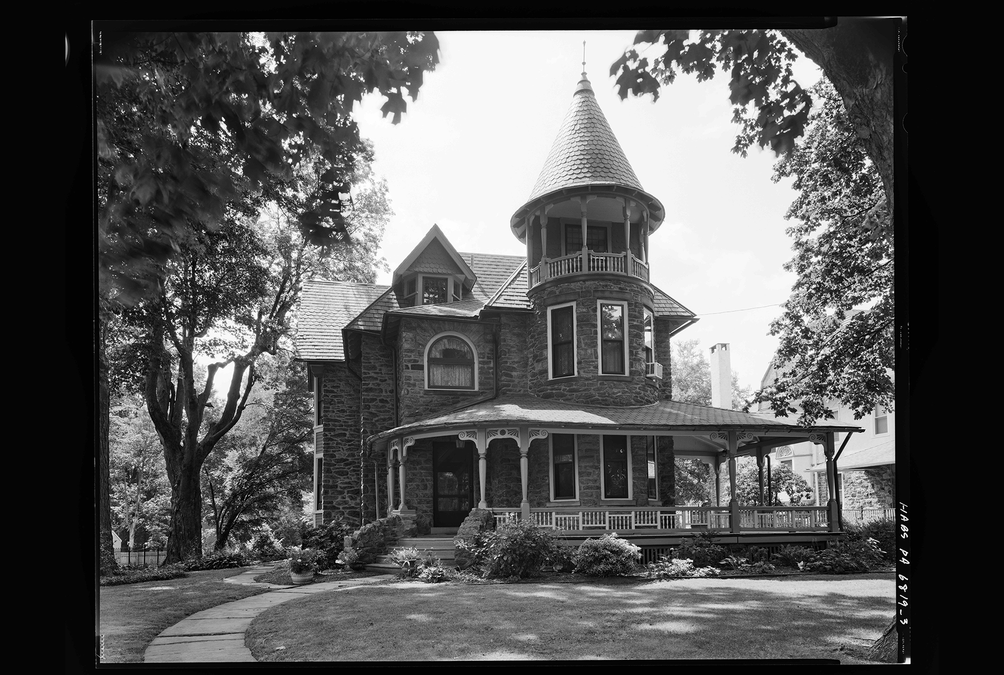 three-story house with a porch and a turret
