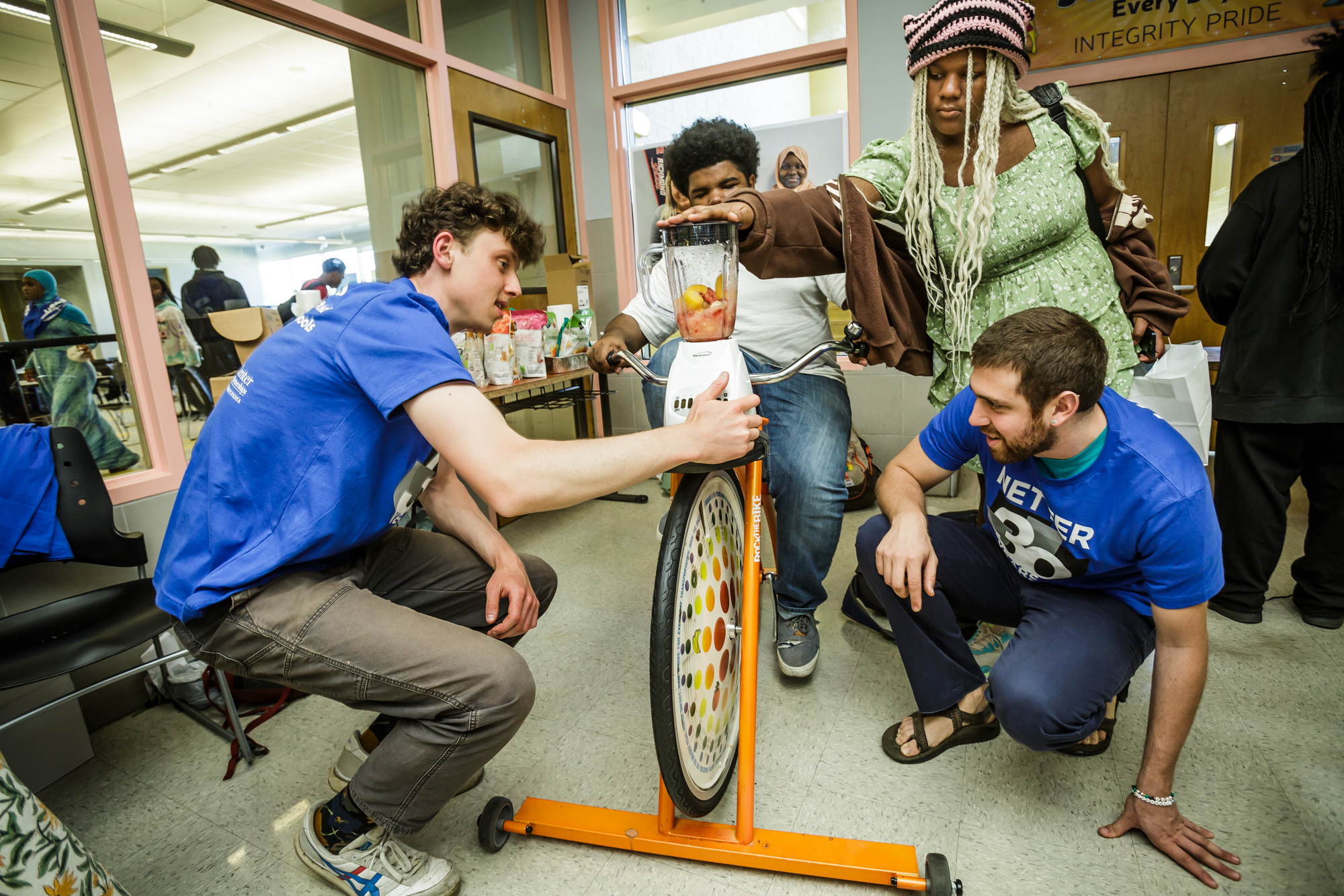 A student pedals a bike to provide energy to power a blender. 