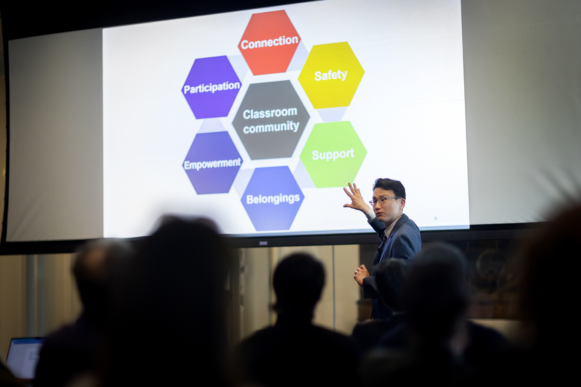 Daeyeon Lee points to a slide that reads 'Classroom community' while delivering a lecture.