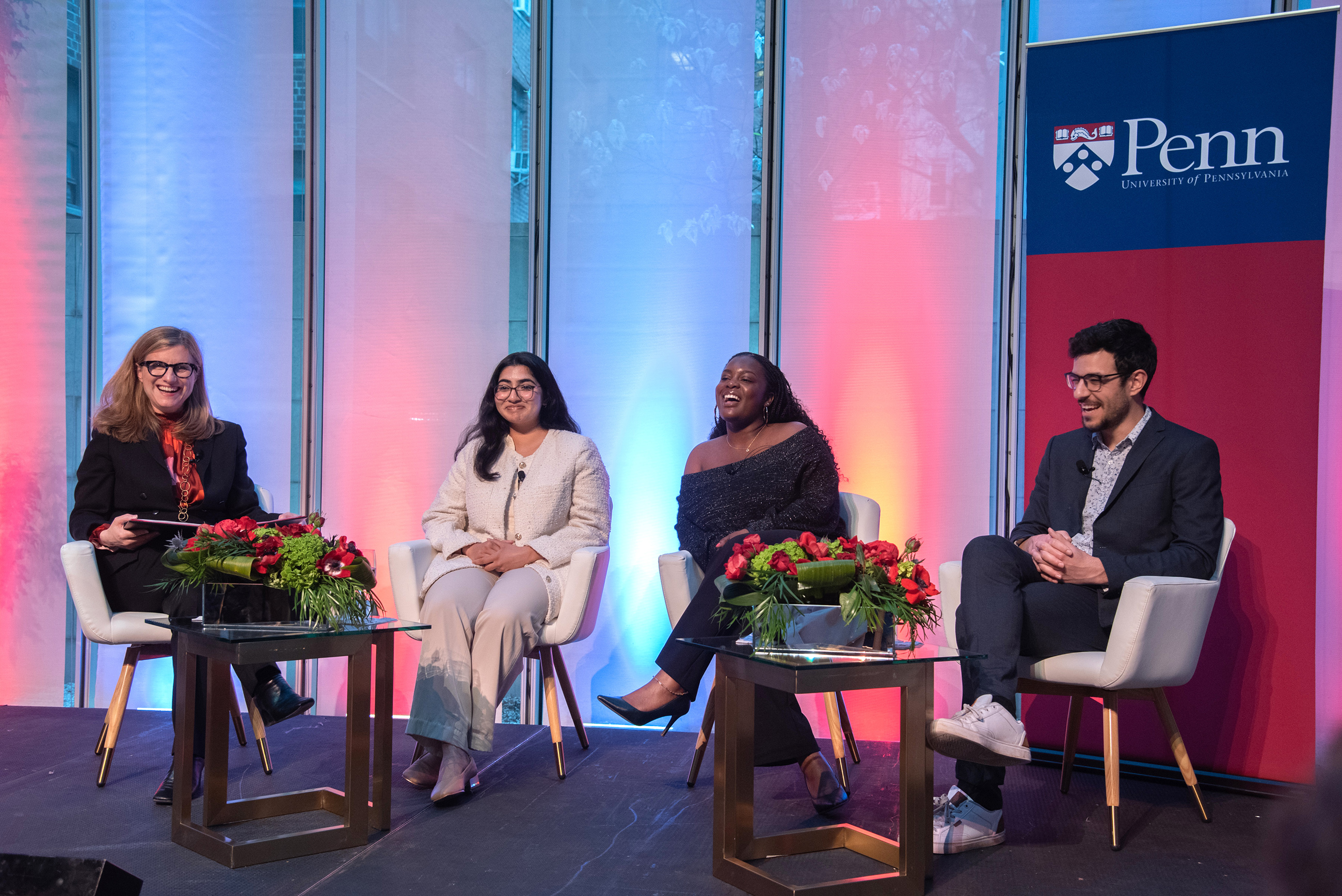 Magill on stage with three students smiling