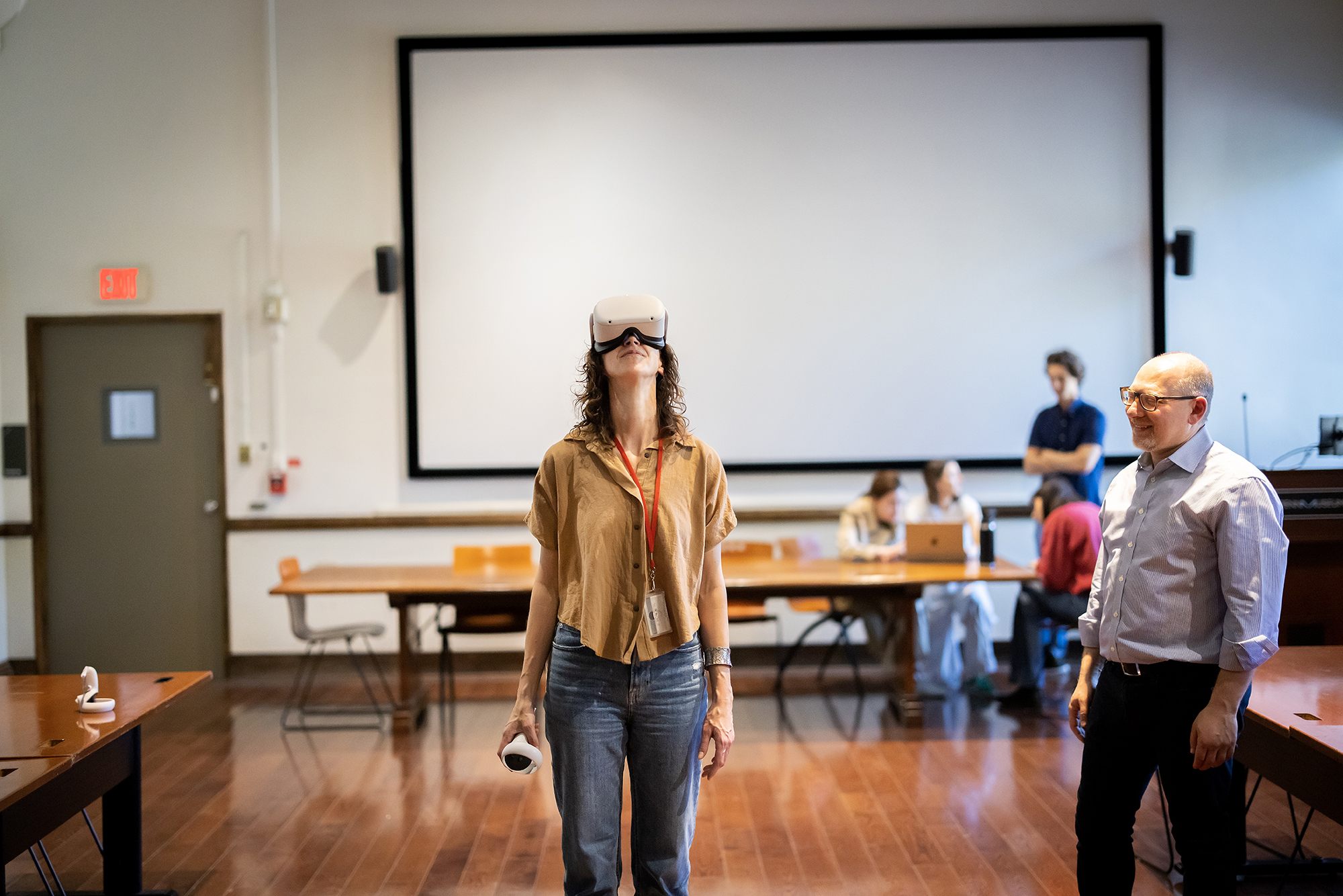 A student wearing VR goggles in a classroom with Peter Ducherney.