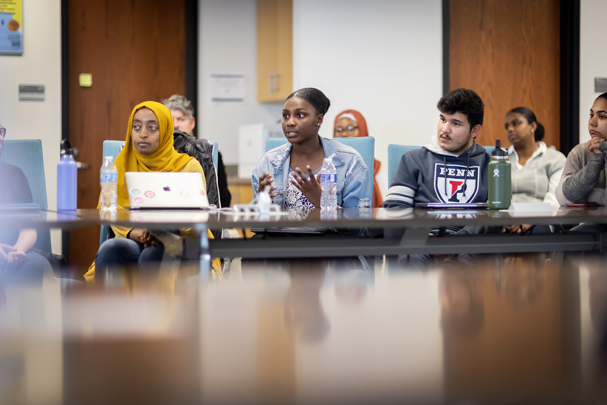 Students in class ask questions of a speaker