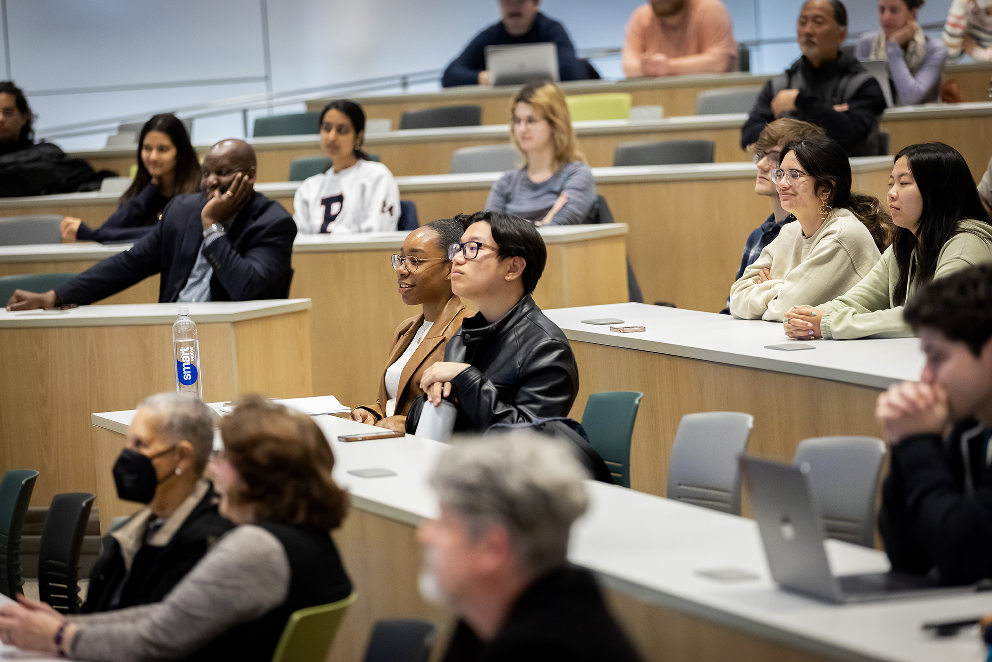lecture attendees pay attention to a speaker in an auditorium