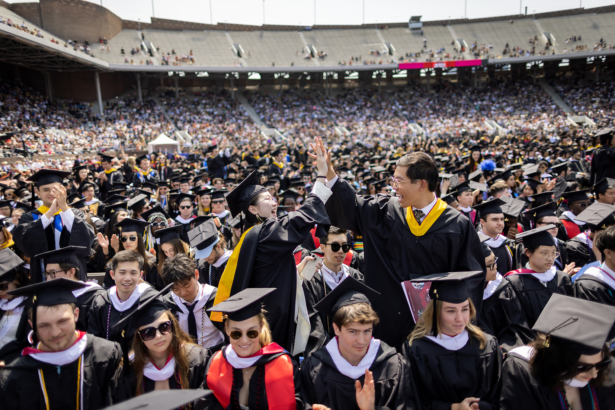 students high five during commencement