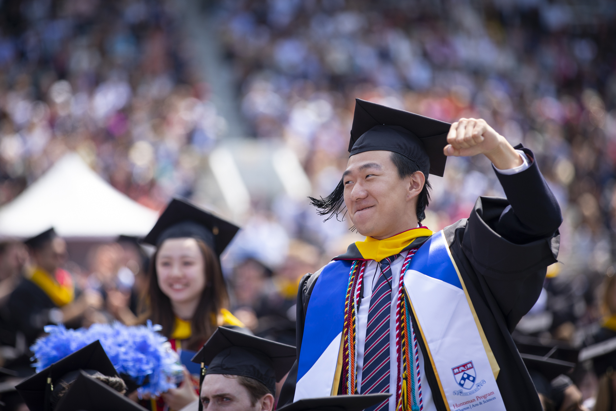 student with fist pump in the air during commencement in franklin field