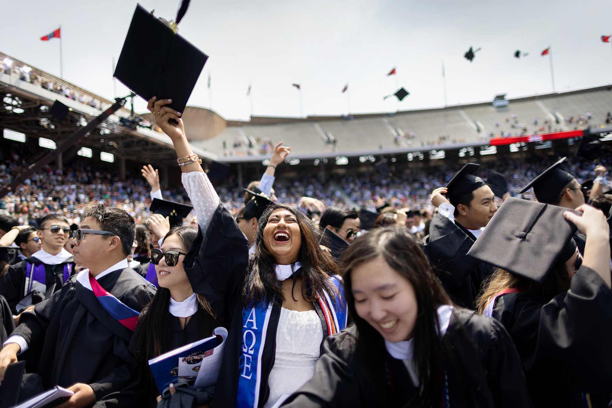 student celebrates with hat in air