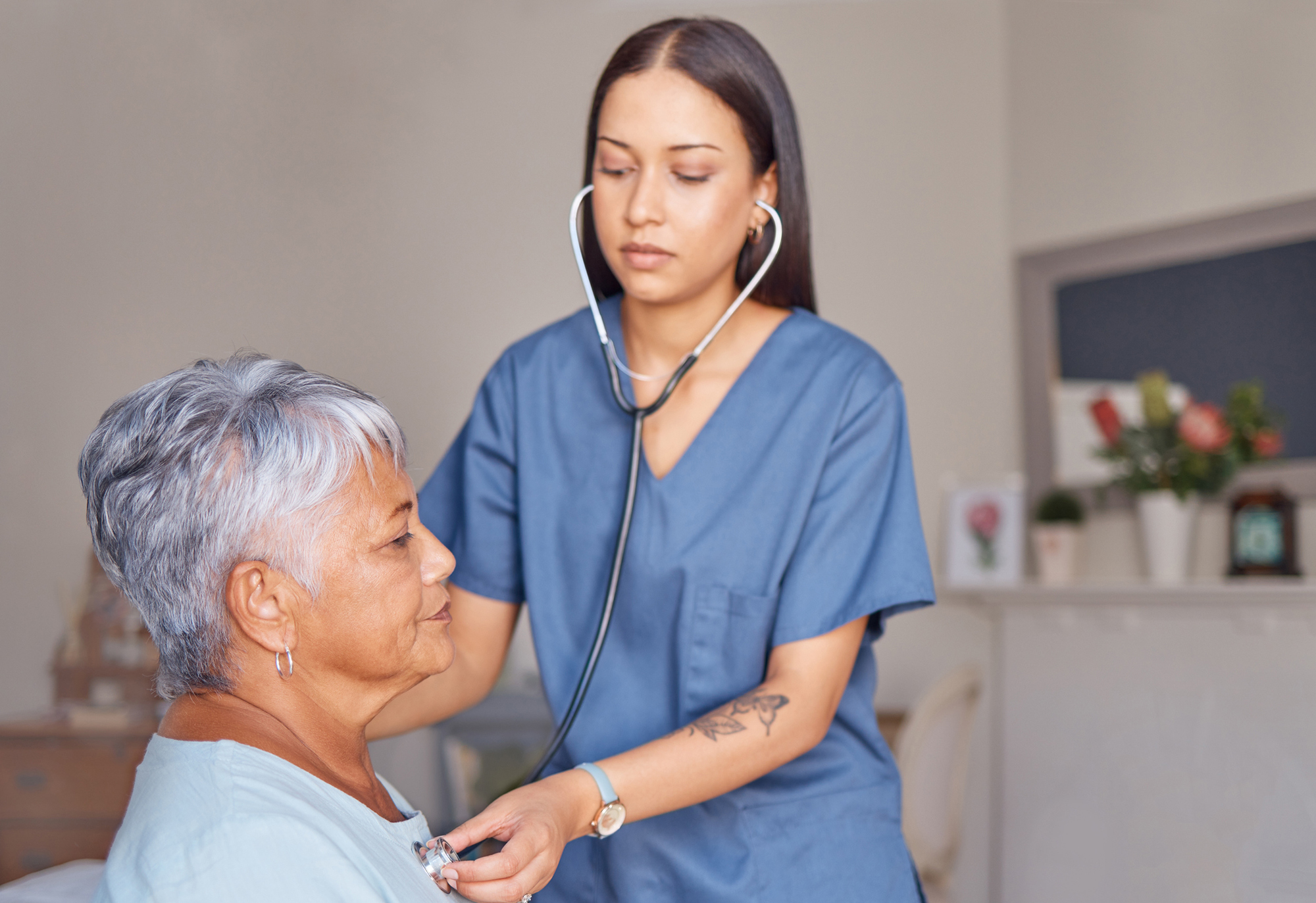 A home health worker checks the heartbeat of a senior patient.