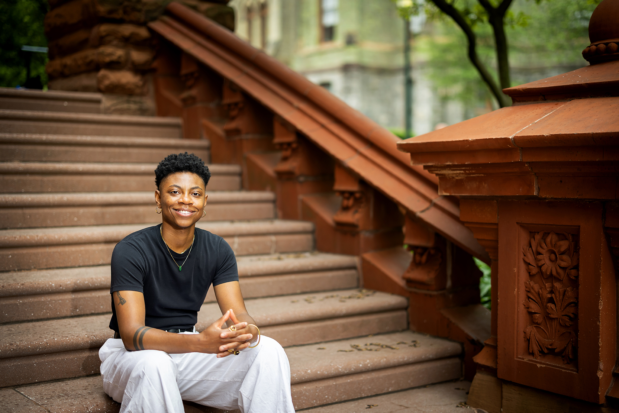Tamir Williams sits on outdoor steps, smiling. 