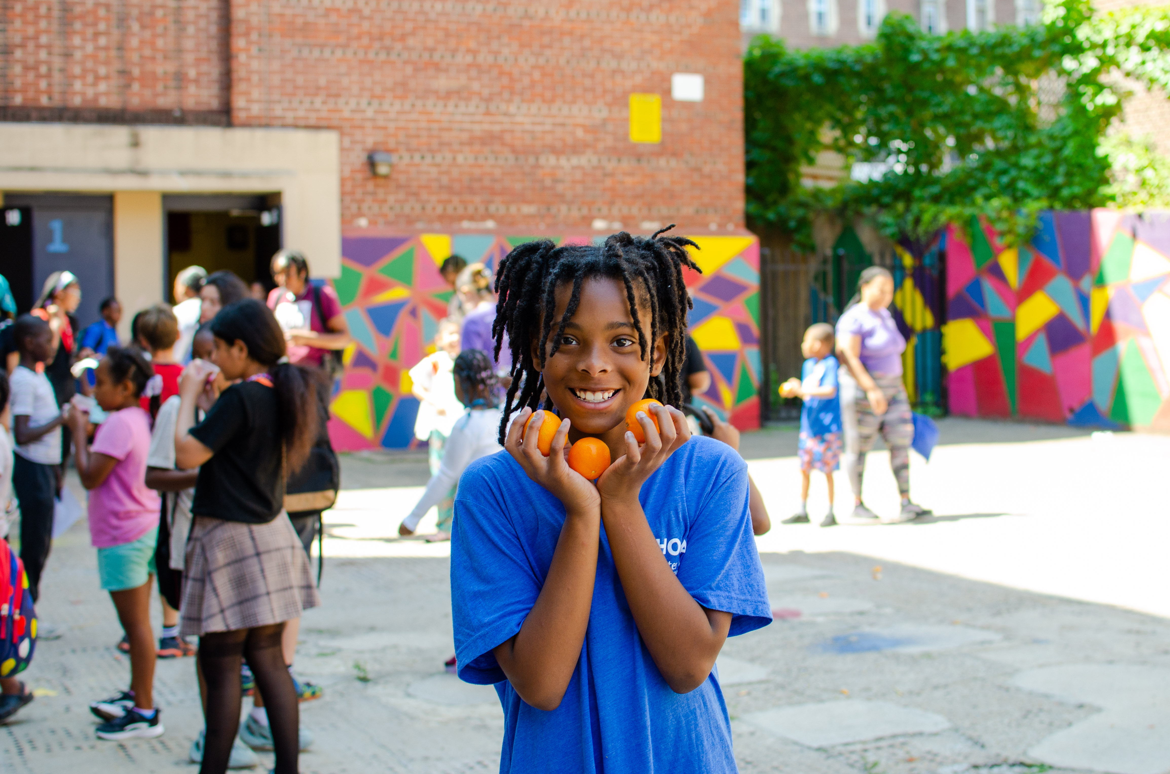 A child at Lea Elementary hold three clementines in her hands