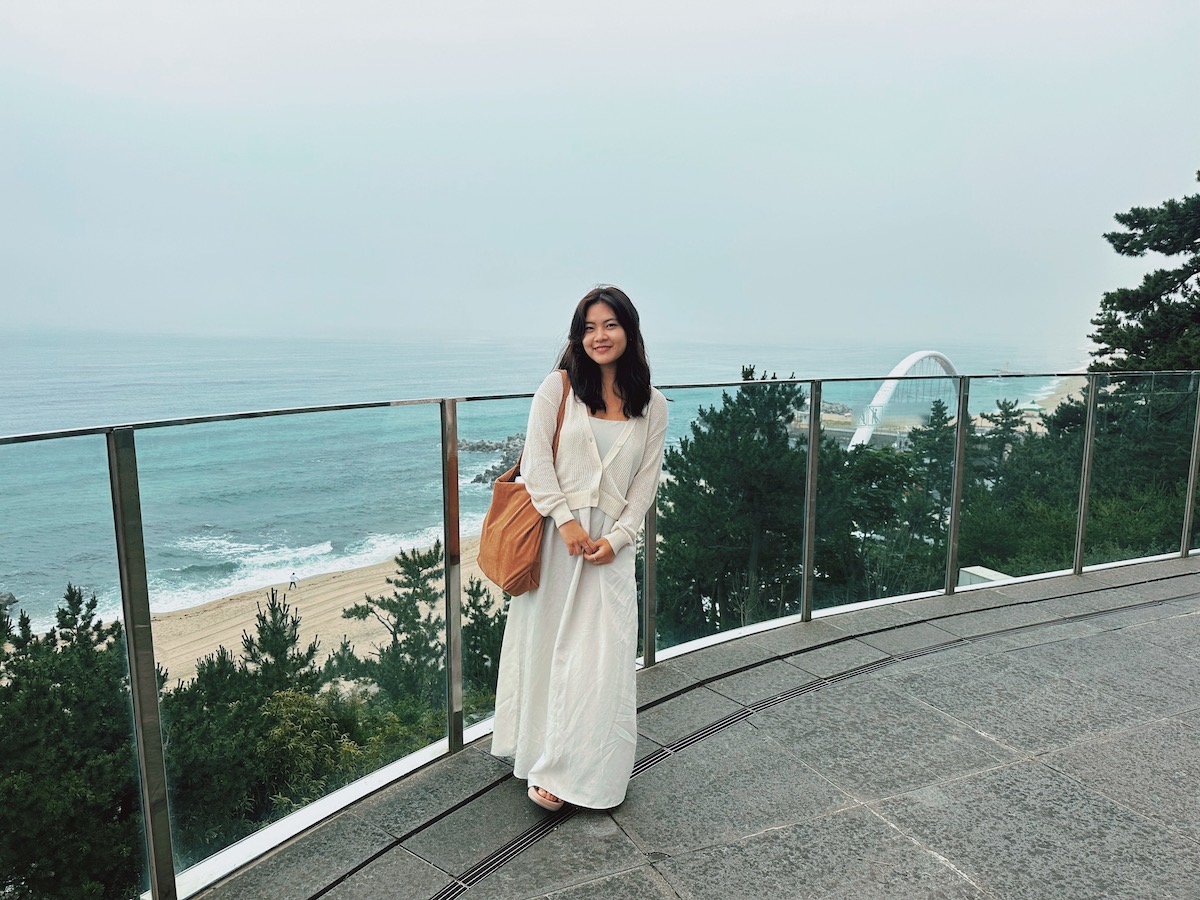 Penn undergrad Claire Jun stands on a balcony overlooking the beach in Gangneung, South Korea., 