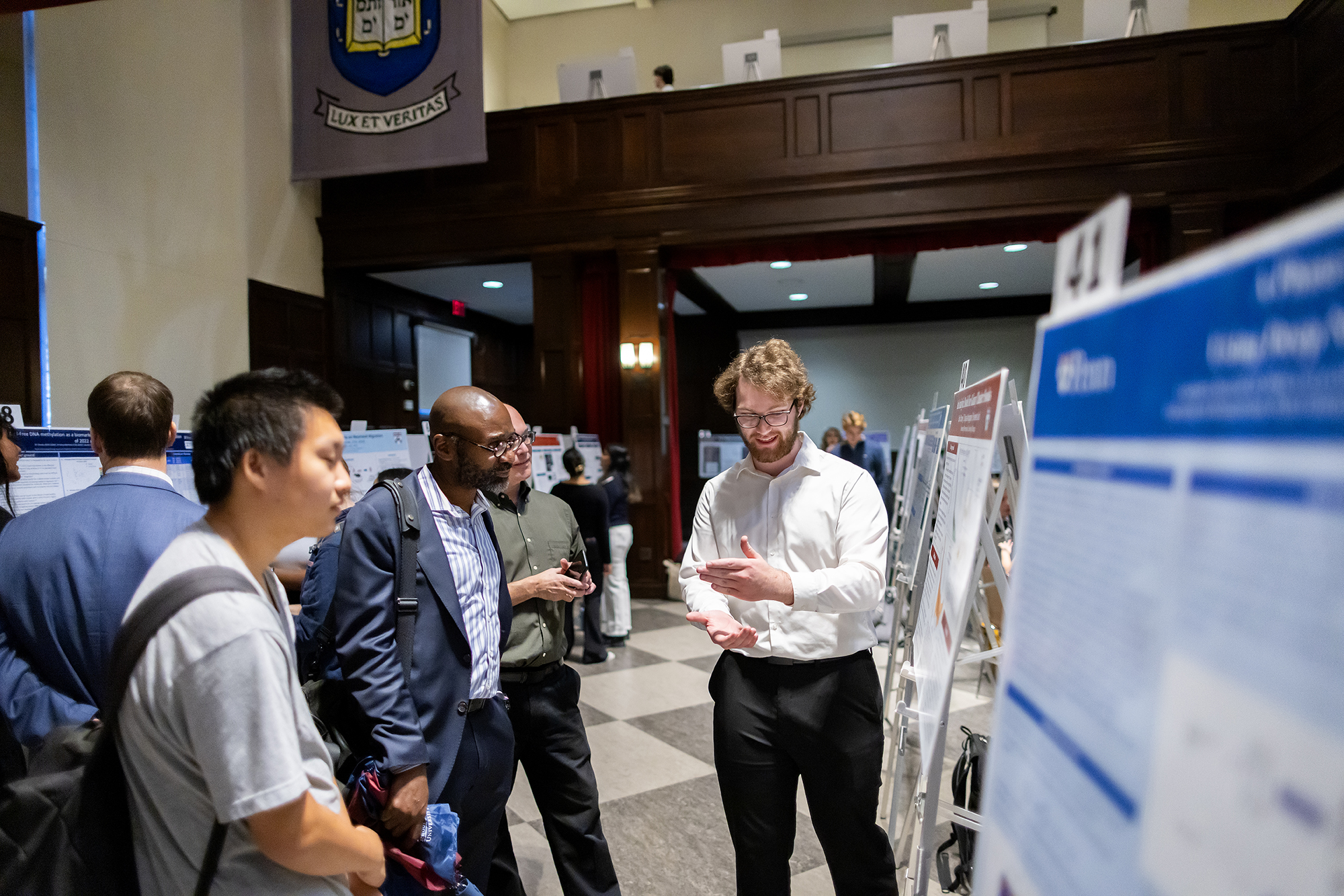A student discusses their poster with John L. Jackson Jr. 