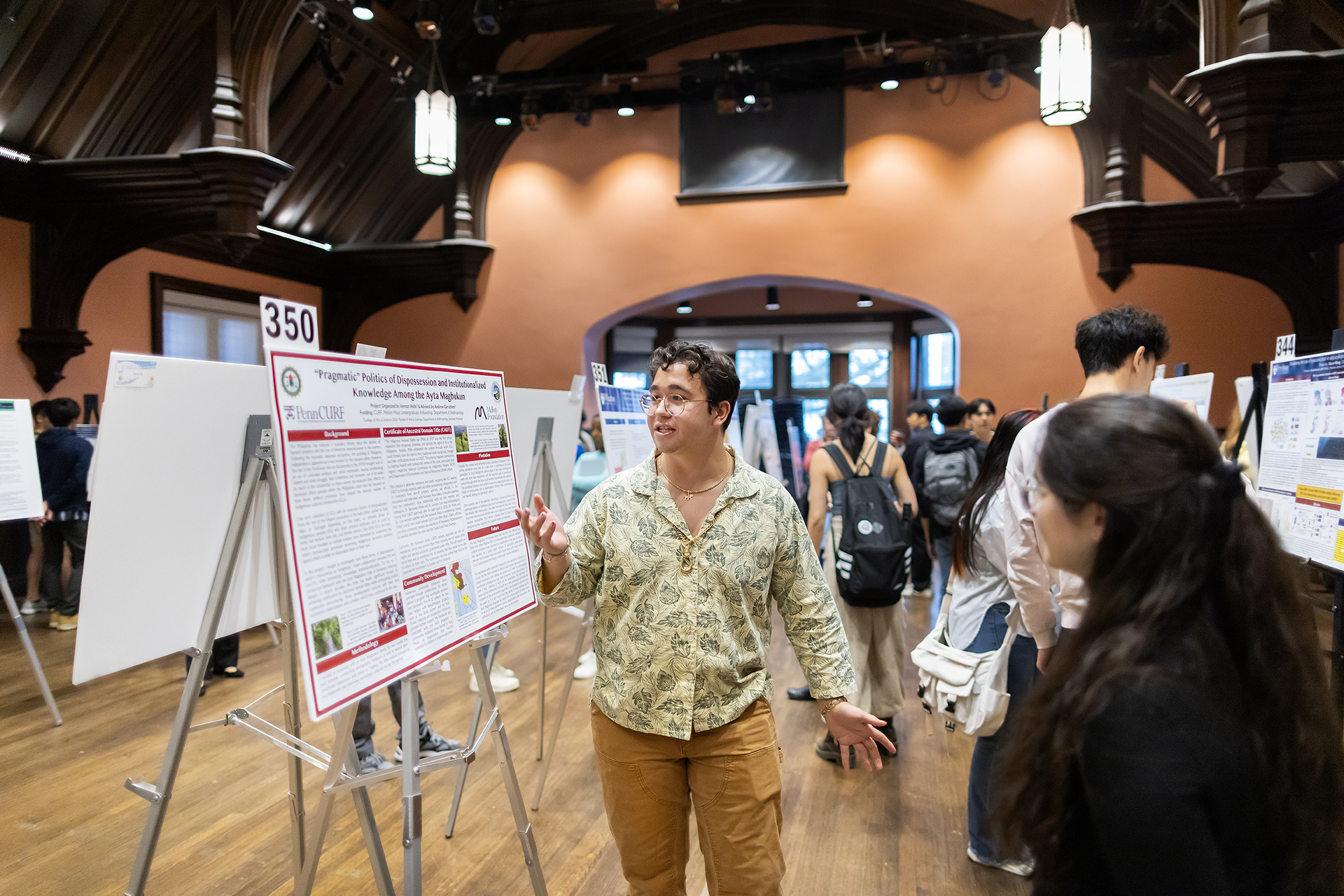 A student discusses their poster with others at the CURF poster expo.
