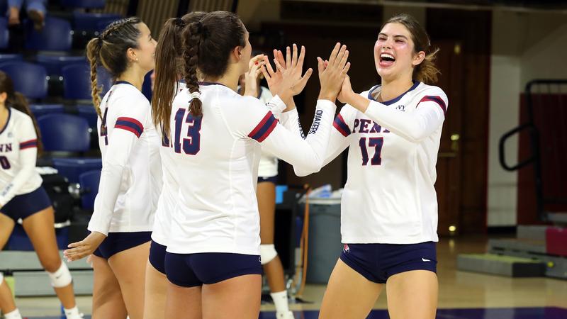 Members of the volleyball team high five after a big play.