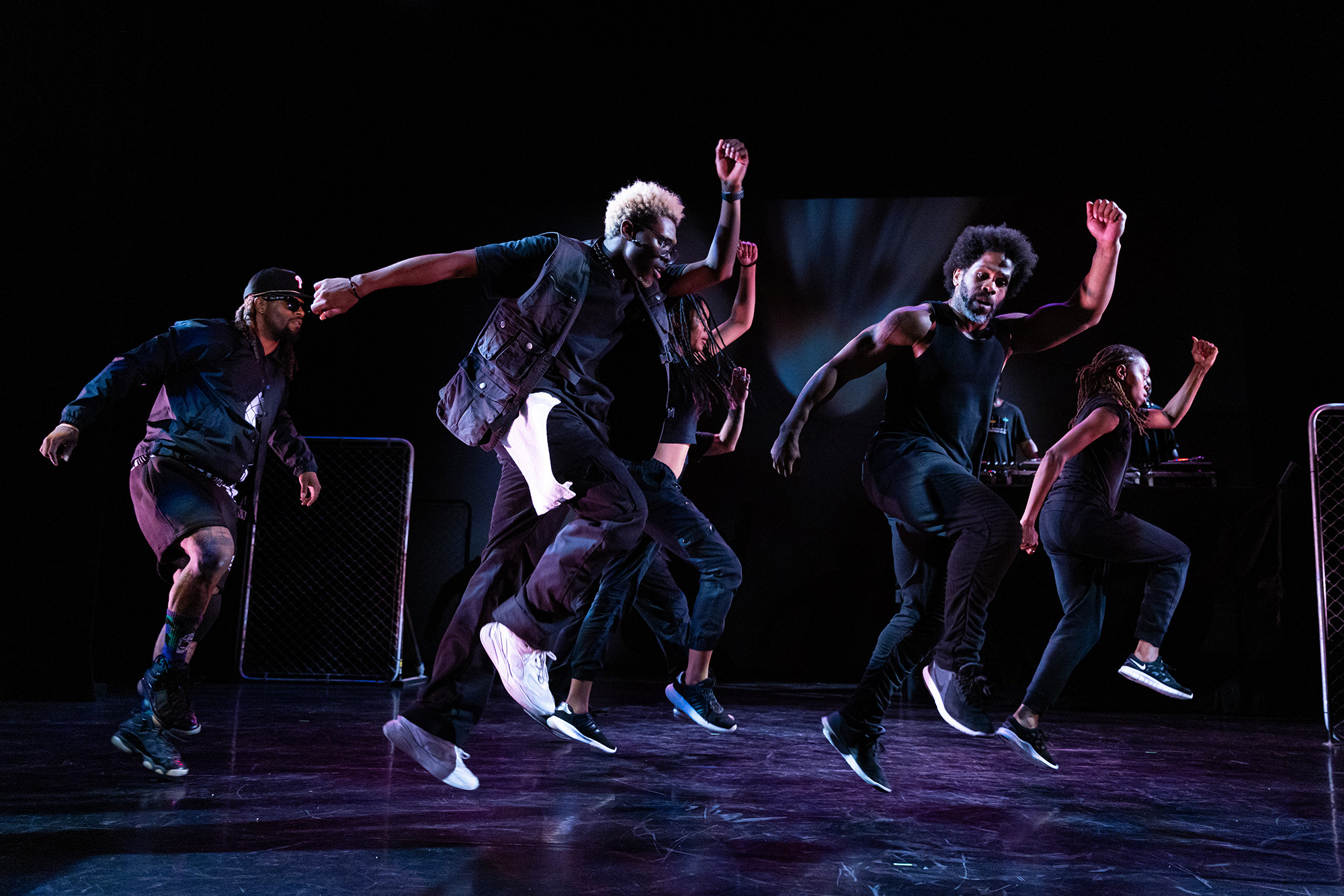 A five-person dance troupe performing on stage.