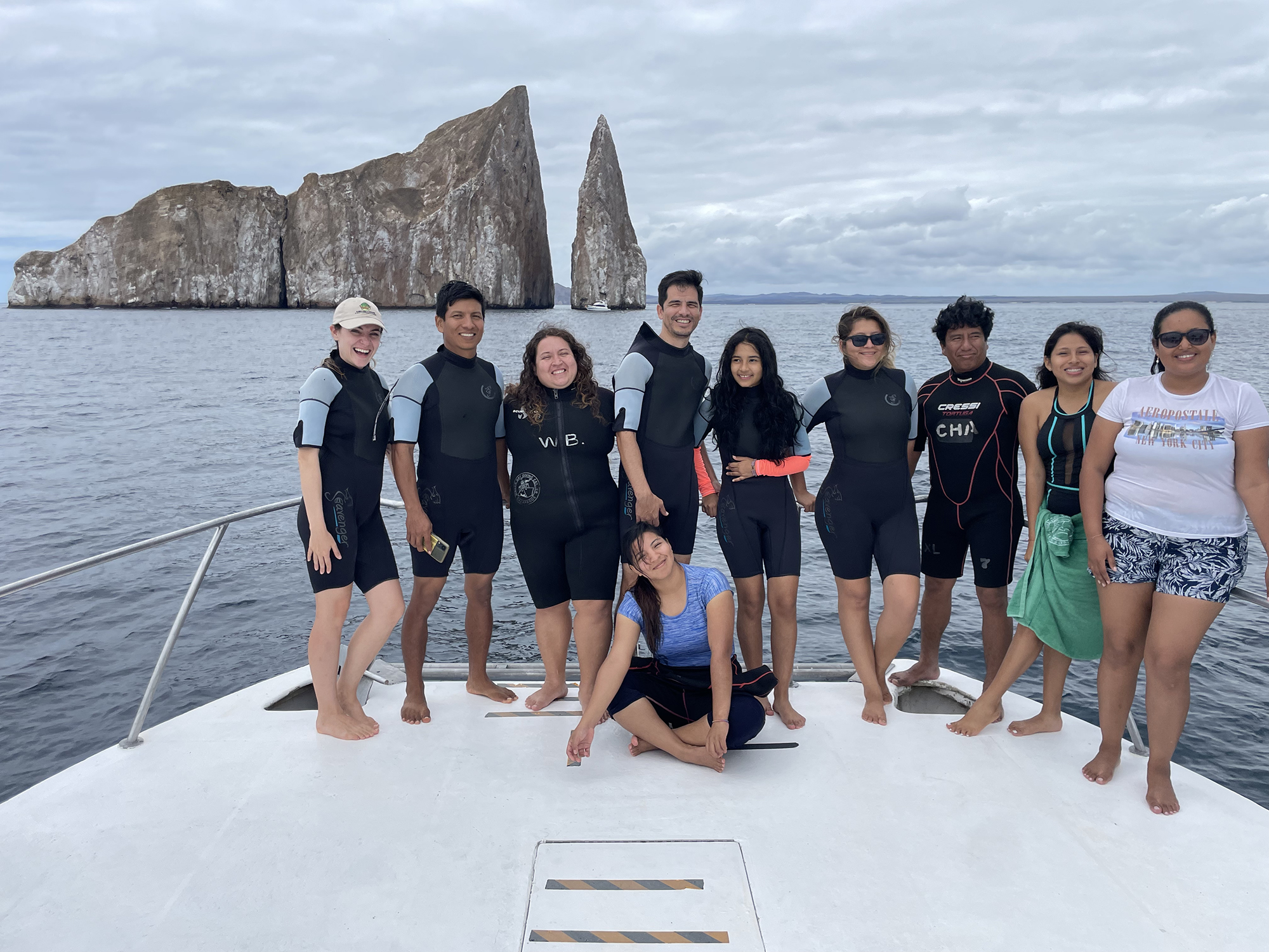 galapagos students standing on the edge of a boat