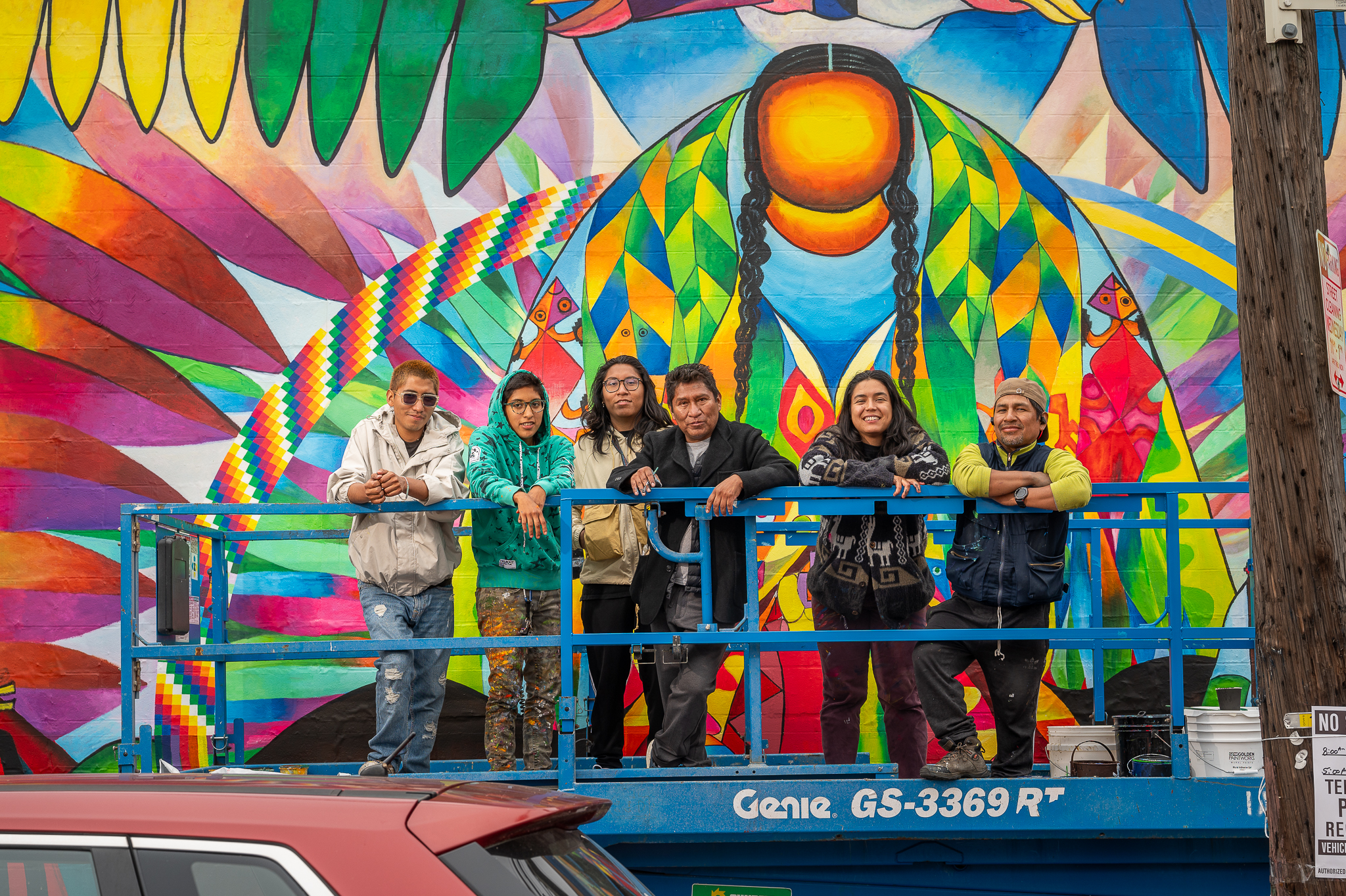 Ibi Padrón Venegas stands with Roberto Mamani Mamani and crew in front of the mural with the image of Pachamama at the center