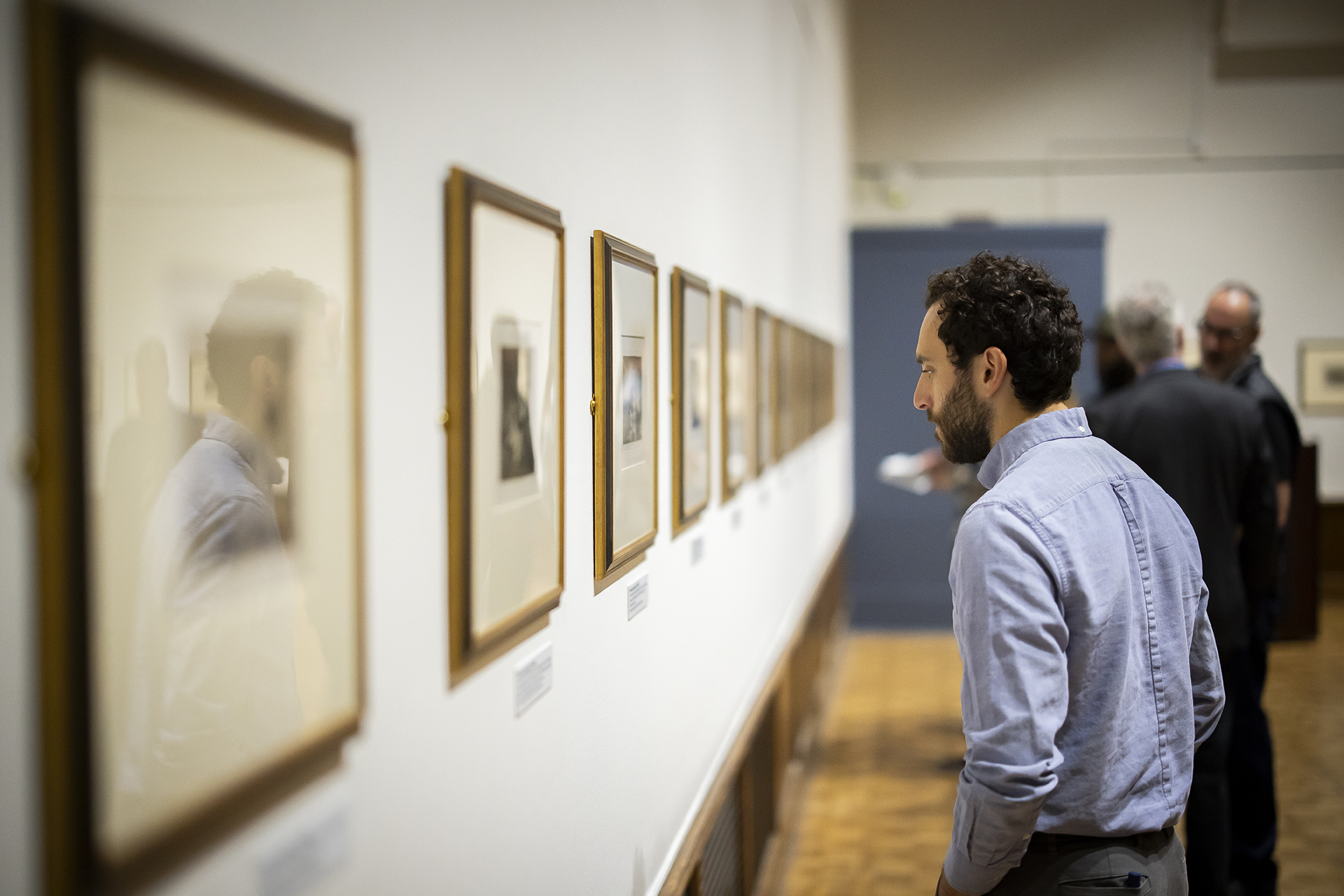A person looks at the artworks on the Gallery wall. 