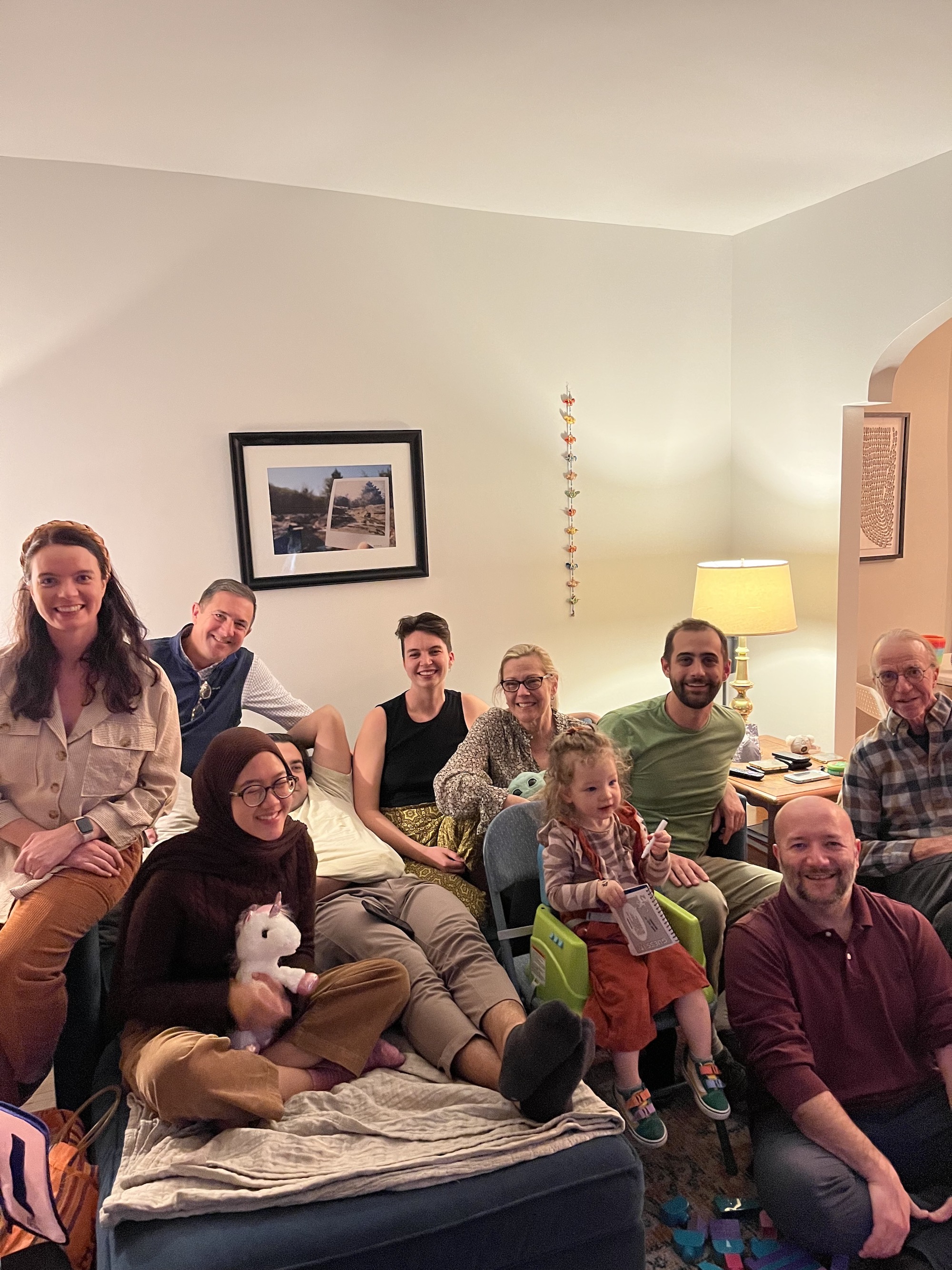 A group of people pose on a living room couch after Thanksgiving dinner.