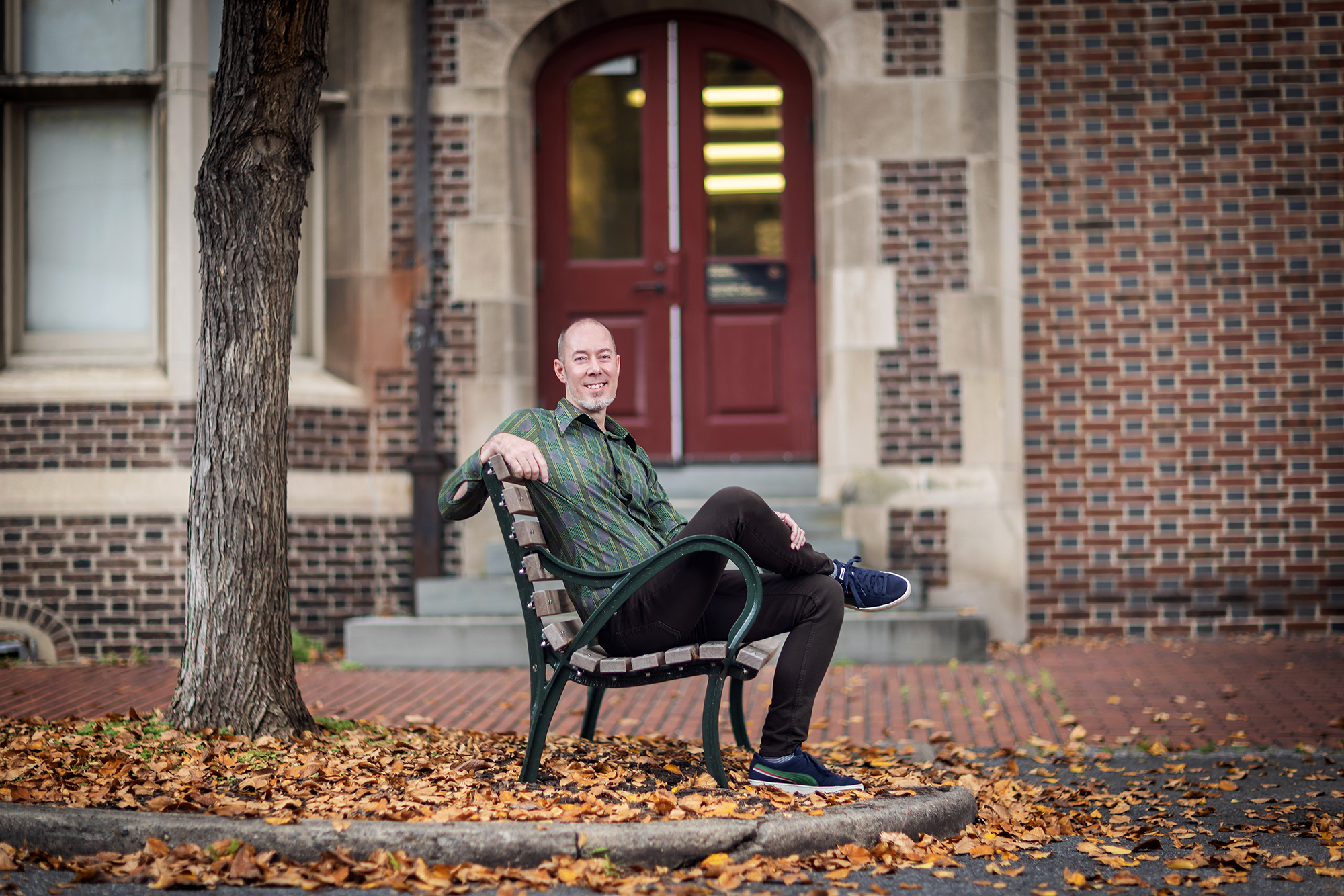 John Donges sitting on a bench in an outside courtyard
