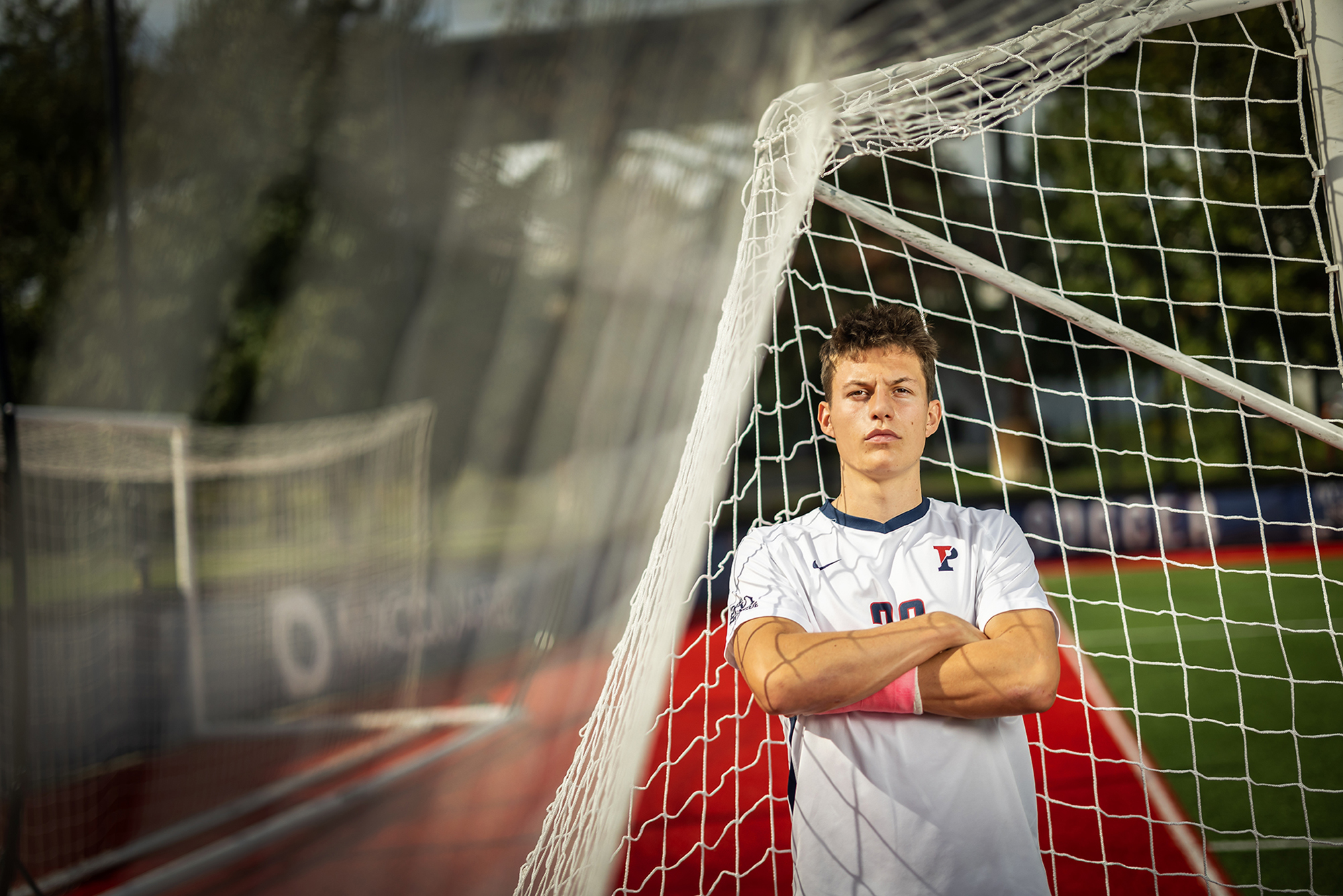 Stas Korzeniowski stands with his arms folded inside a goal at Penn Park.