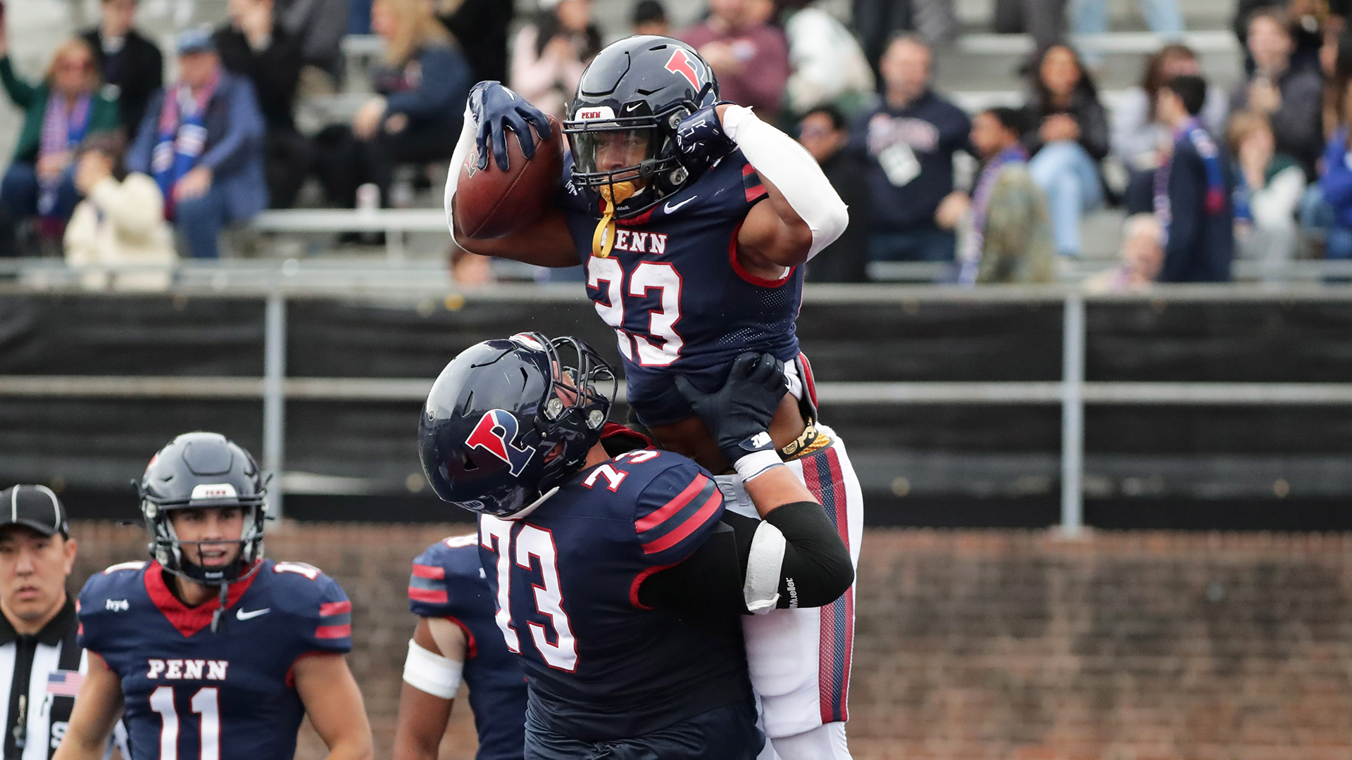 Malachi Hosley flexes while a teammate lifts him in the air after scoring a touchdown against Cornell.