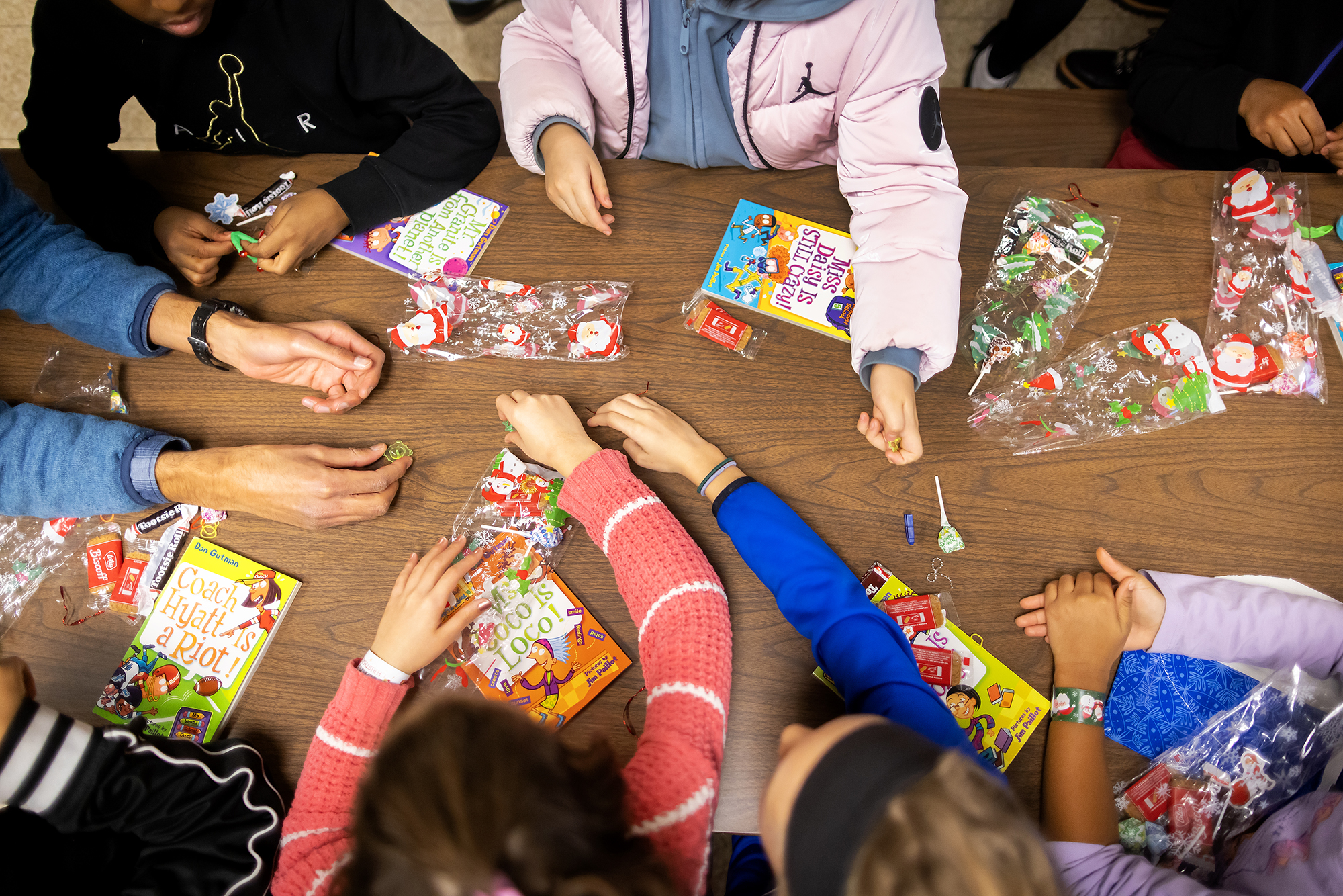 A flat shot of students' hands with books and treat bags