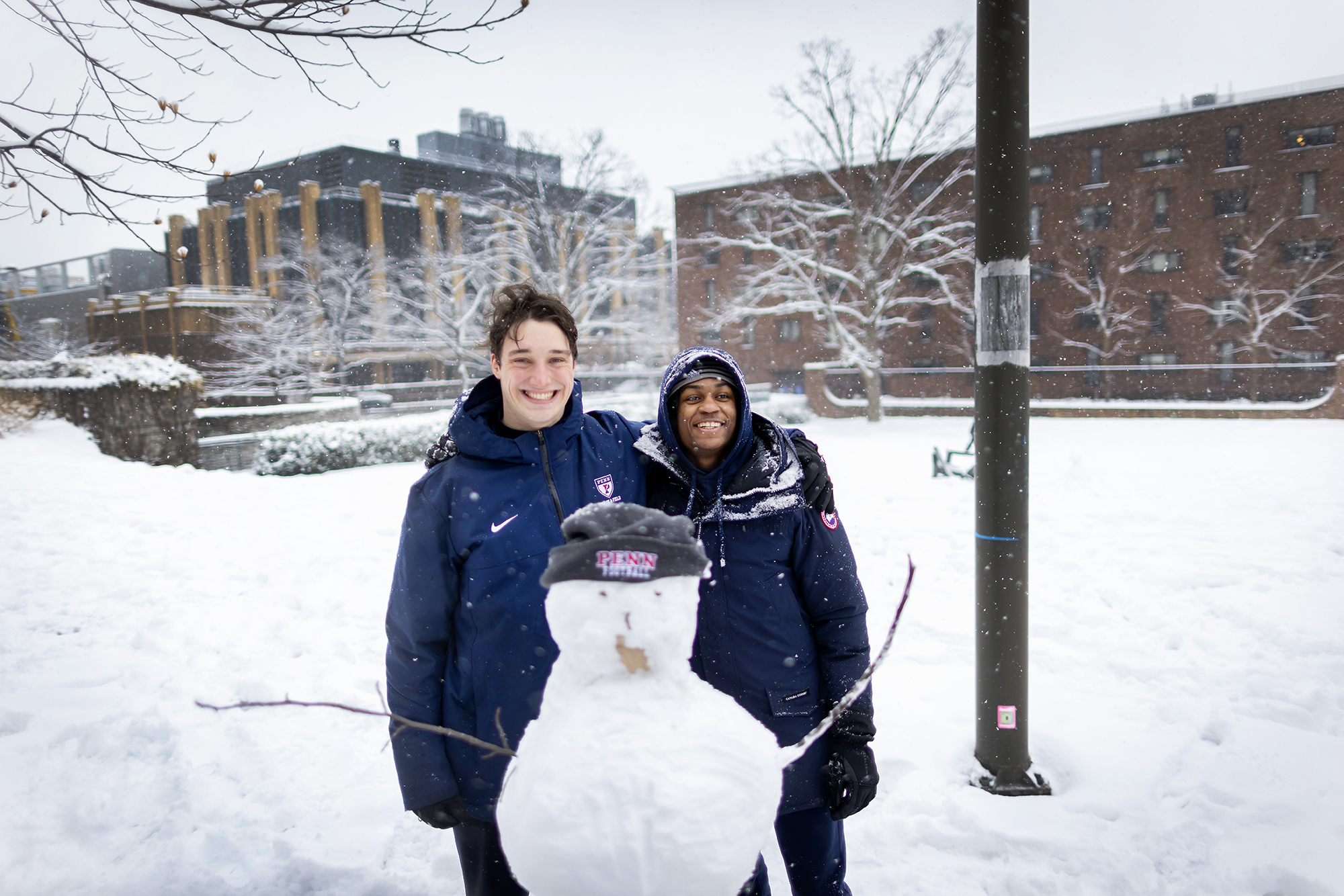 students build a snowman on hill field