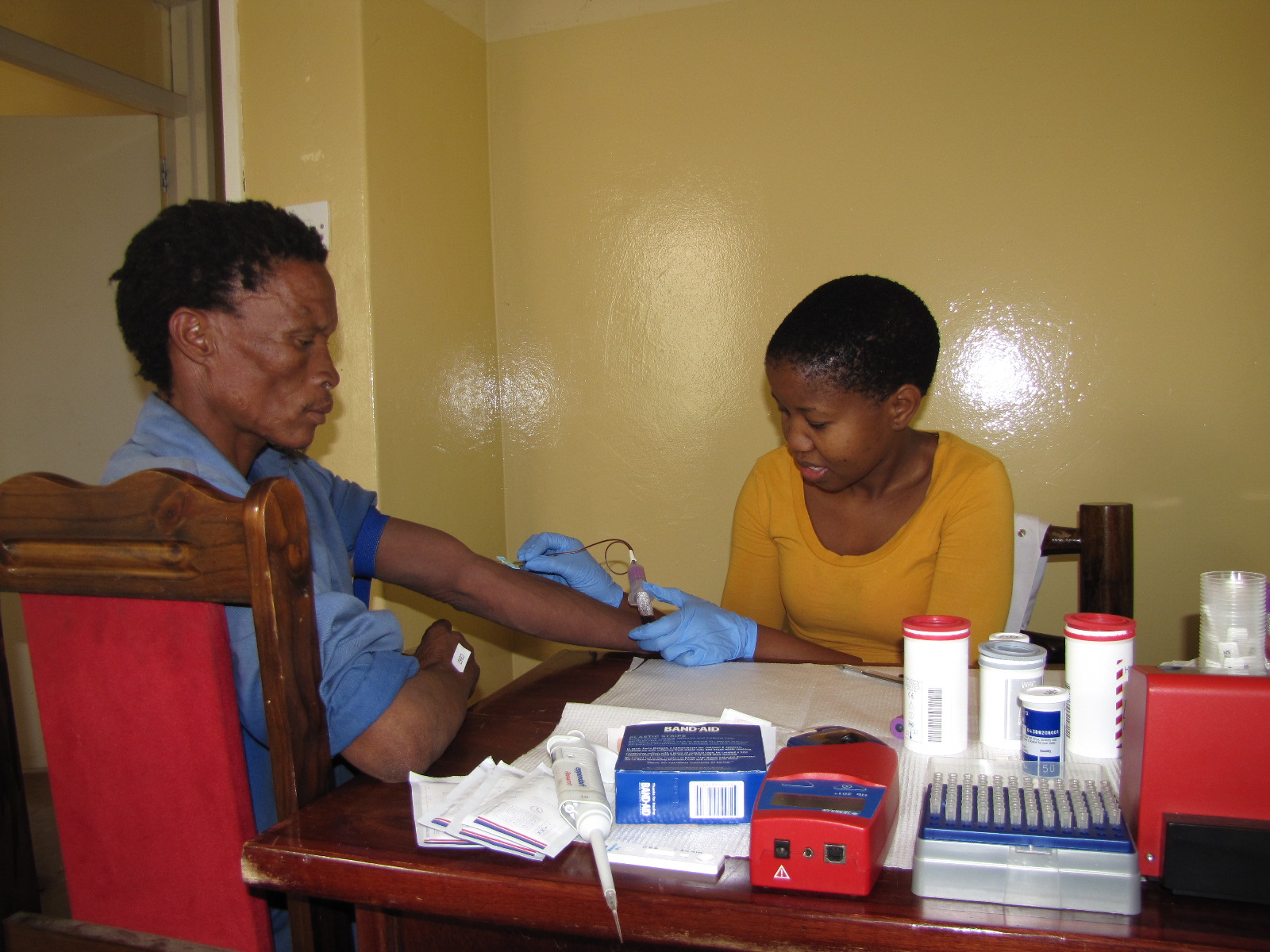 Researcher draws blood sample from participant.