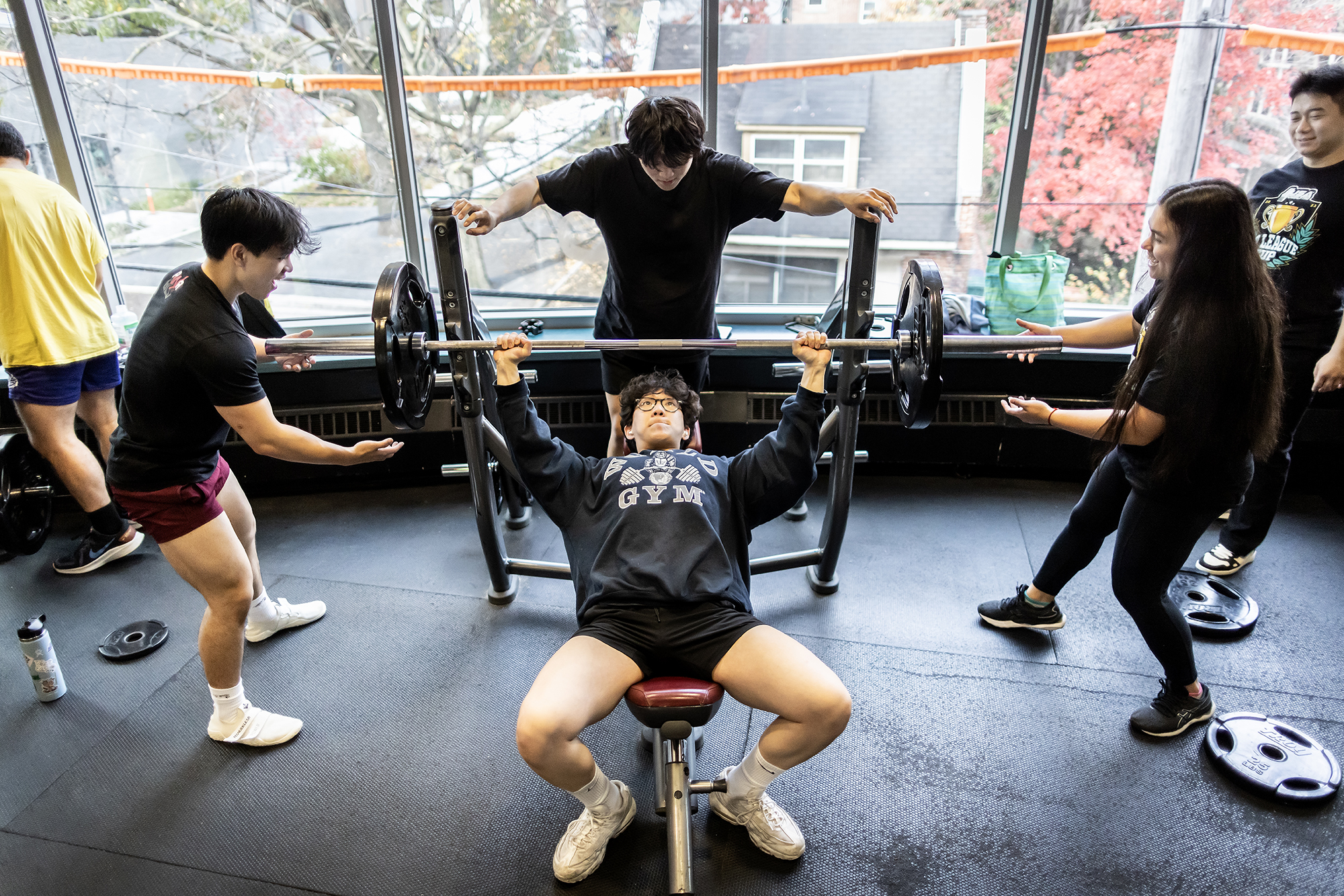 Bryan Yan, a fourth-year finance major in the Wharton School, performs an incline barbell bench press while spotted by Adrienna Davis and two other students.