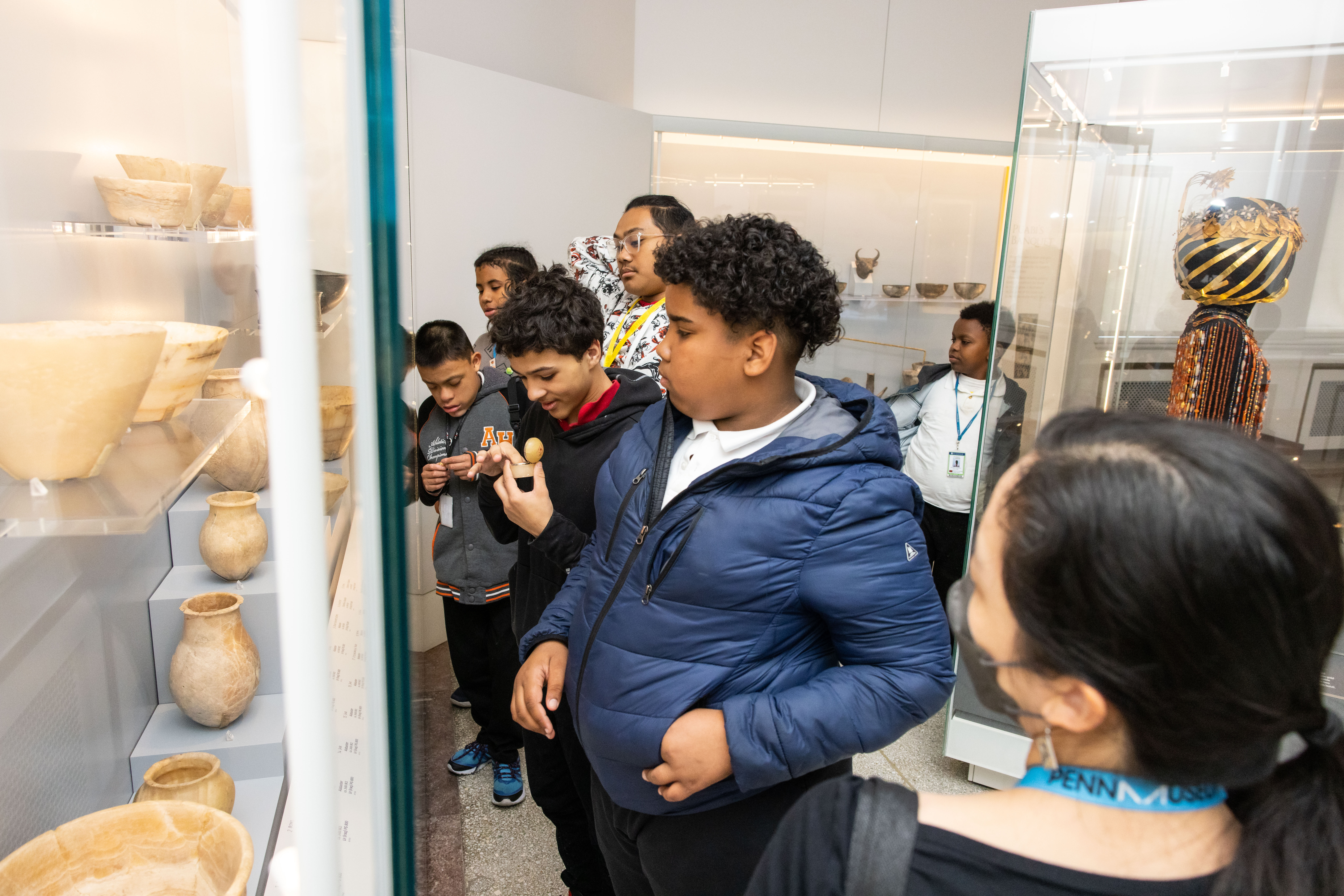 A group of young viewers looking at an exhibit at the Penn Museum.