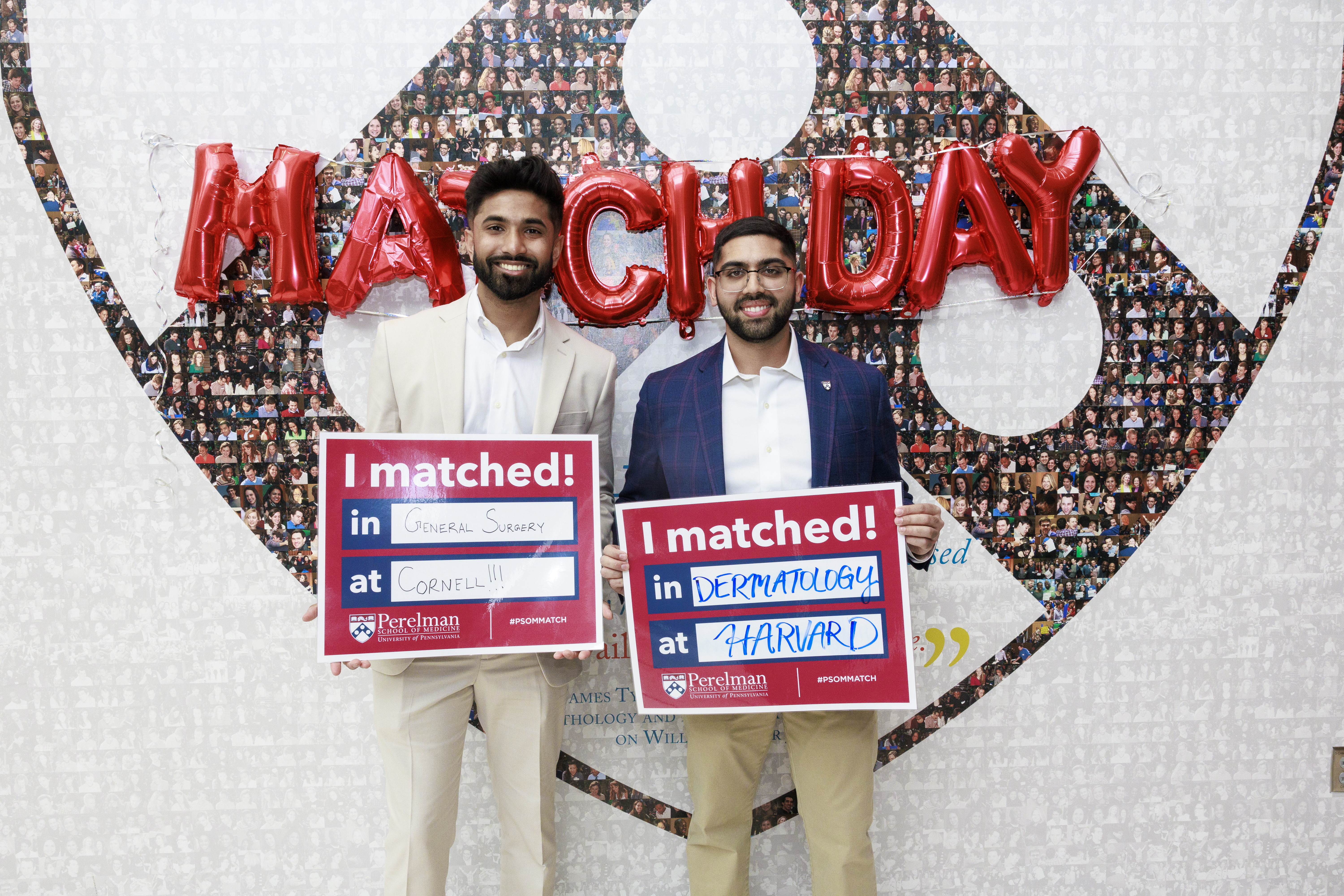 Two students holding Match Day signs in front of Match Day balloons.