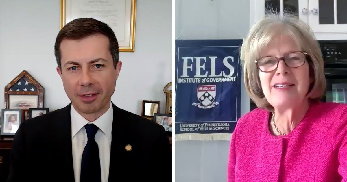 Transportation Secretary Pete Buttigieg sits at his desk in Washington, D.C., in a split screen zoom chat with Elizabeth Vale from Fels Institute of Government in the right frame.