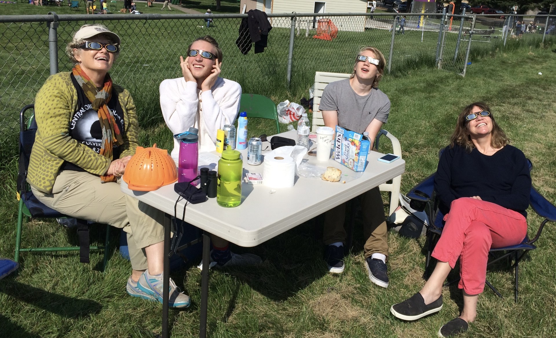 Potgoraph of people with eclipse glasses starring at the sun.