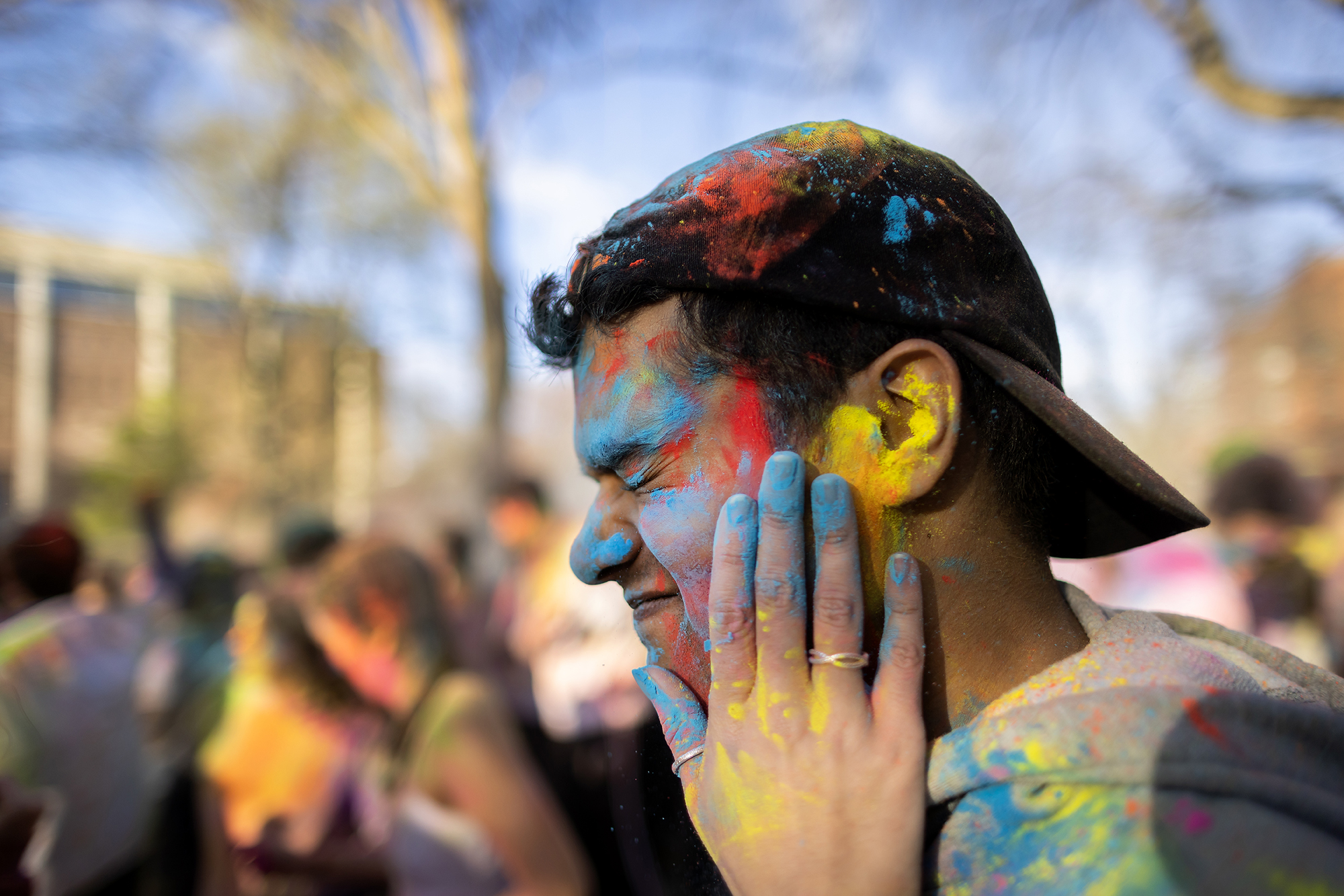 A Penn student rubs powder onto the face of another Penn student during the Holi celebration.