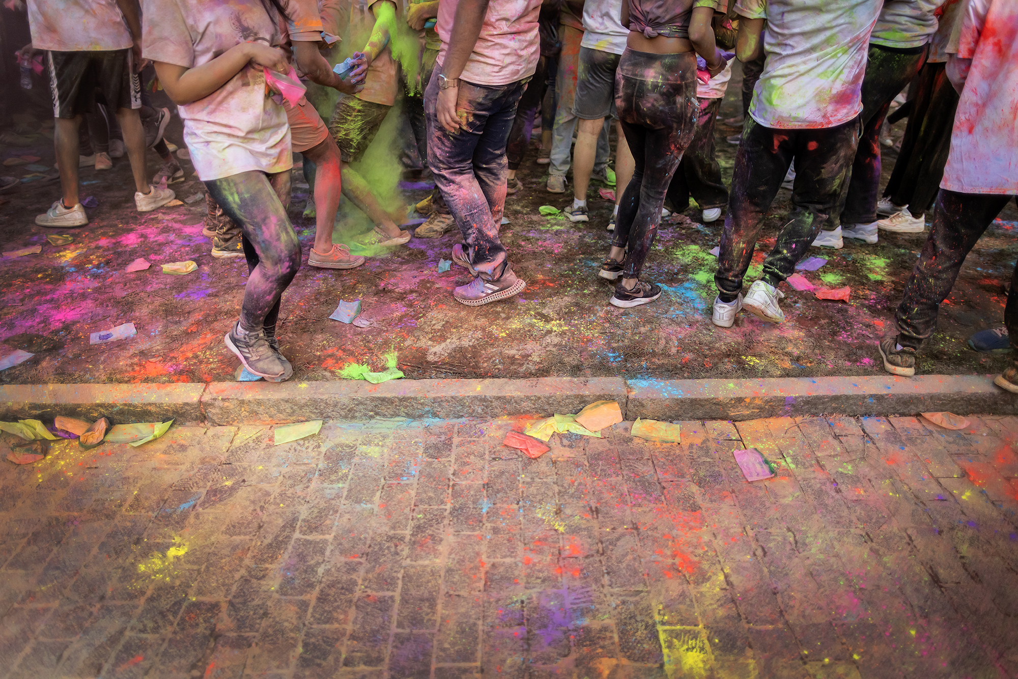 Penn students covered in colored powder on Locust Walk during Penn’s Holi celebration.