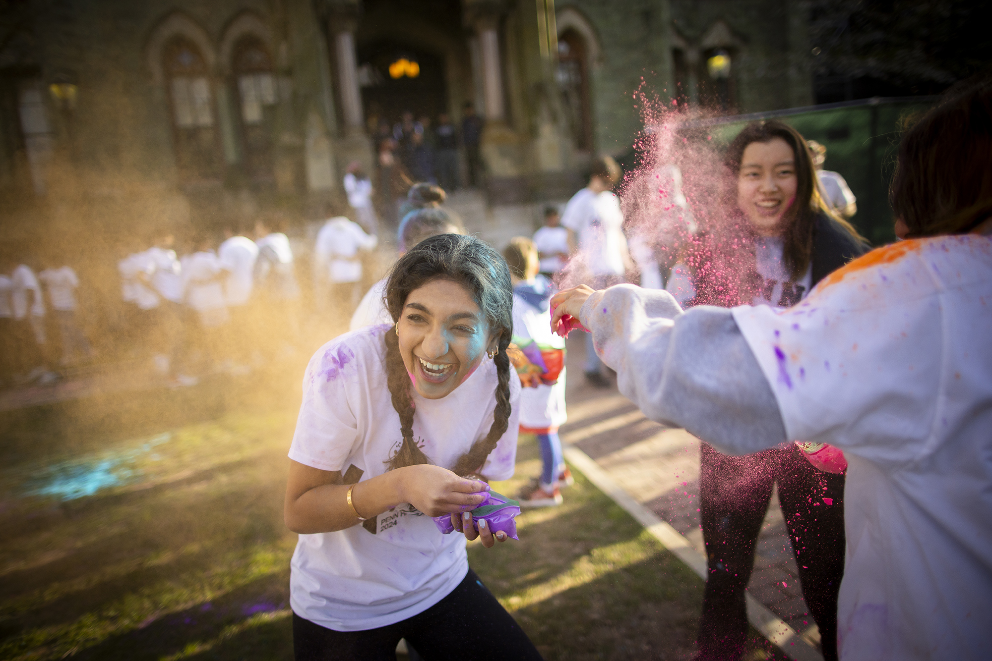 A Penn student laughs as powder is thrown on College Green during Penn’s Holi celebration.