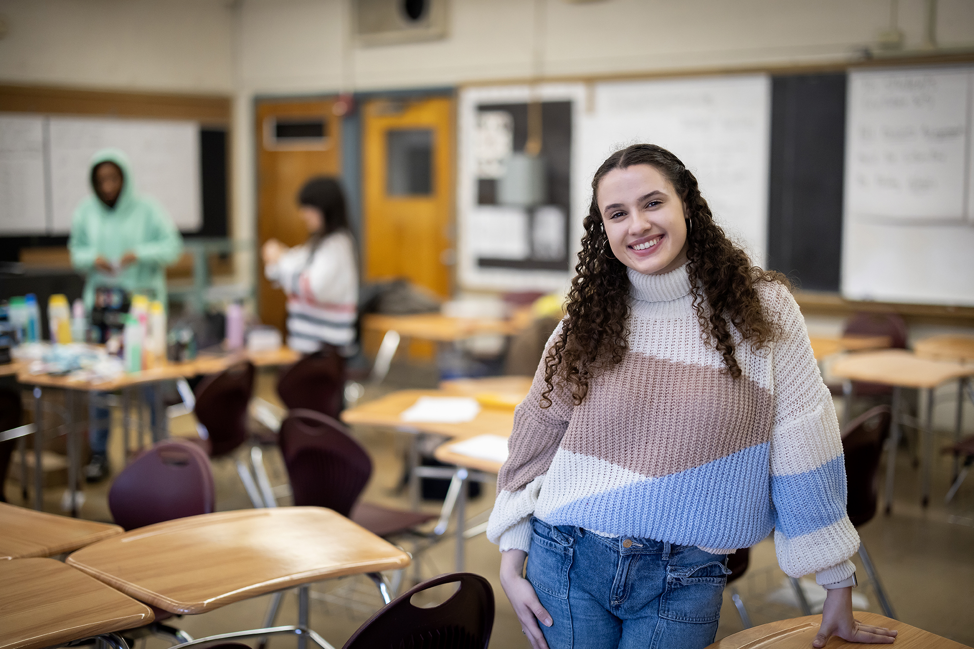 Ariana Jimenez stands in the foreground of a high school classroom