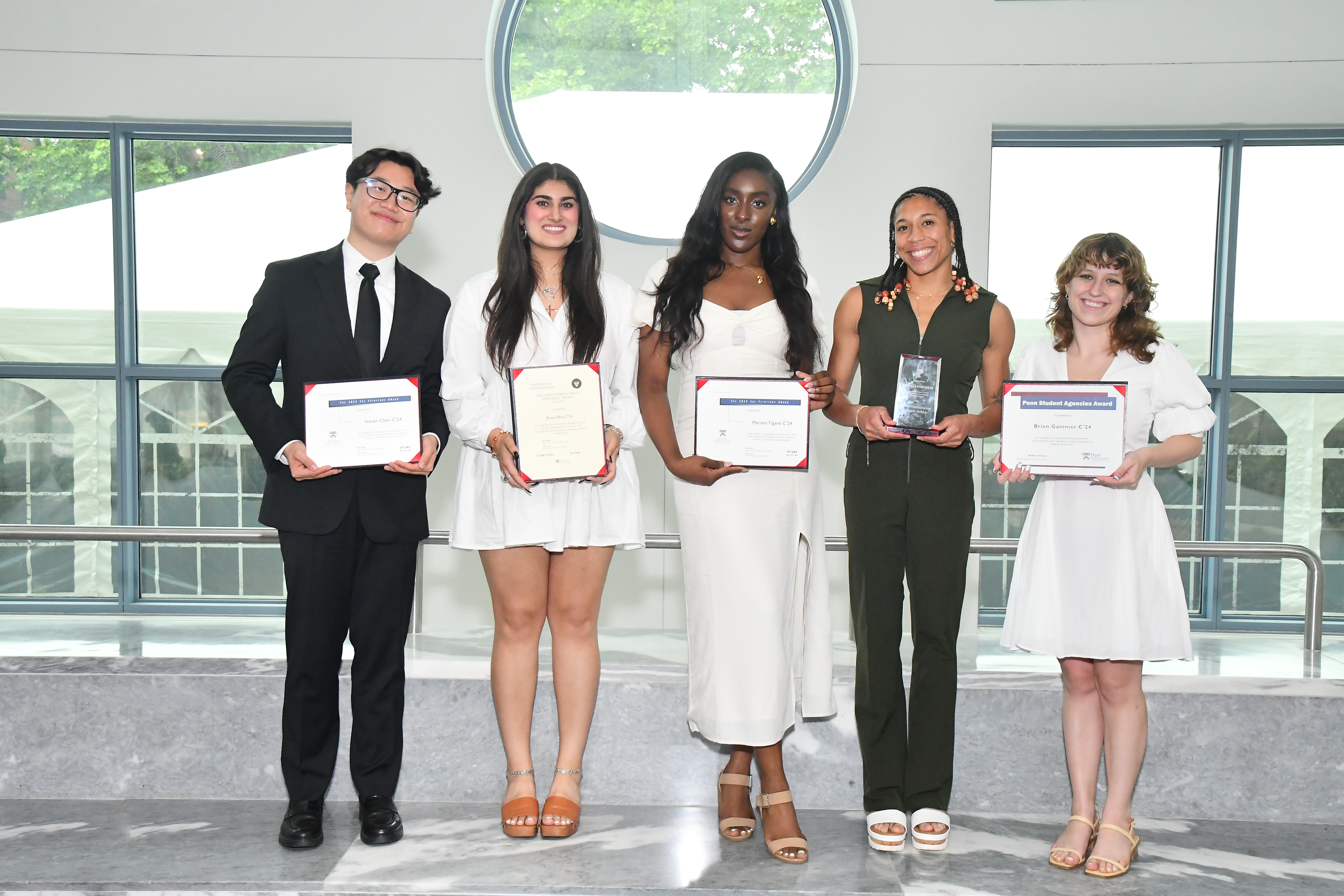 Four students stand with awards