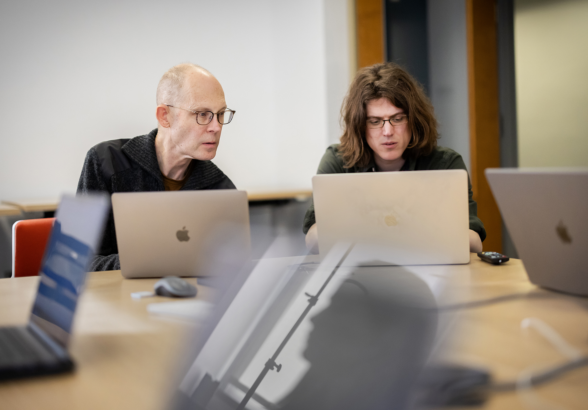 two people looking at laptop computers 