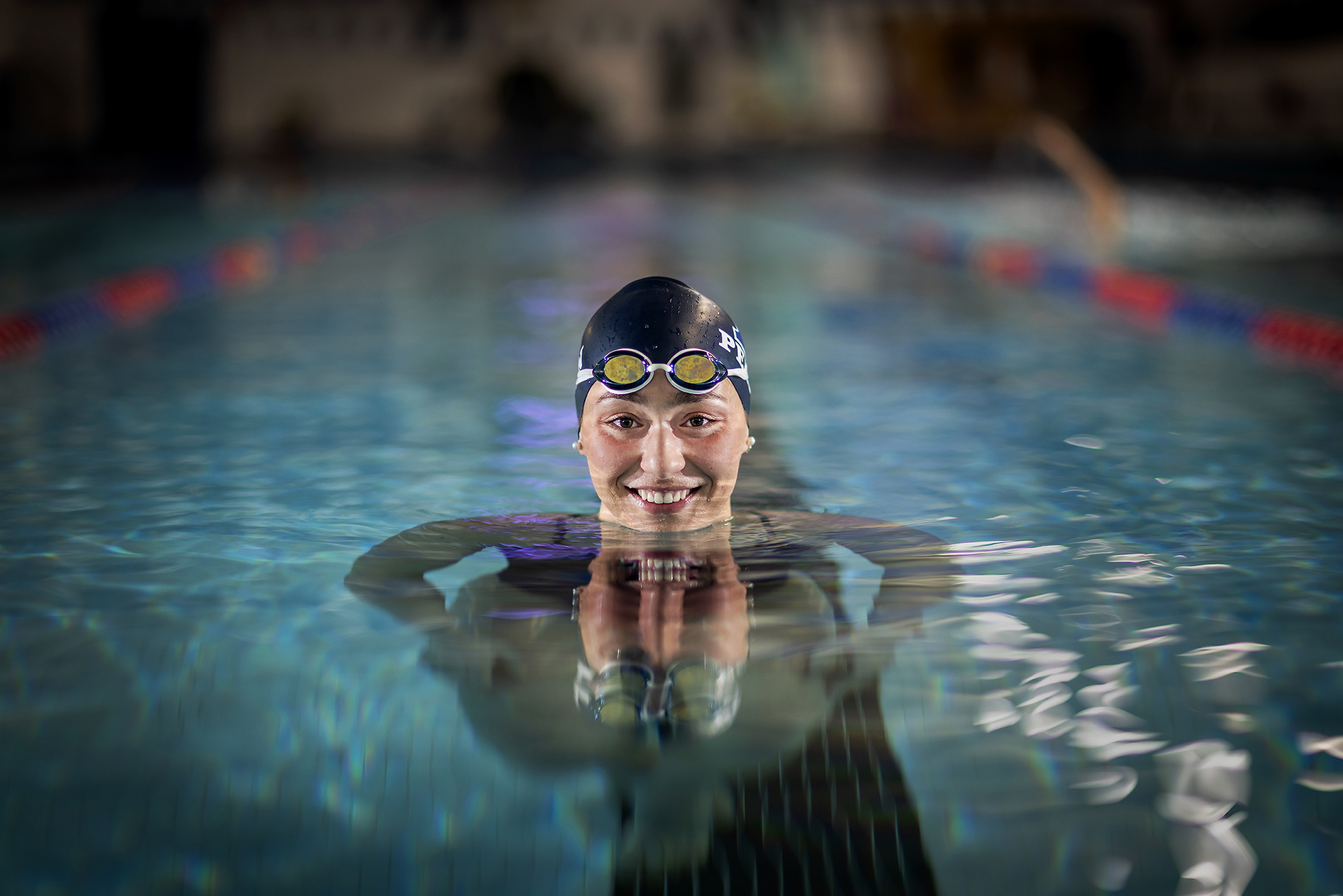 Anna Kalandadze holds her head above the water while wearing her swim cap.