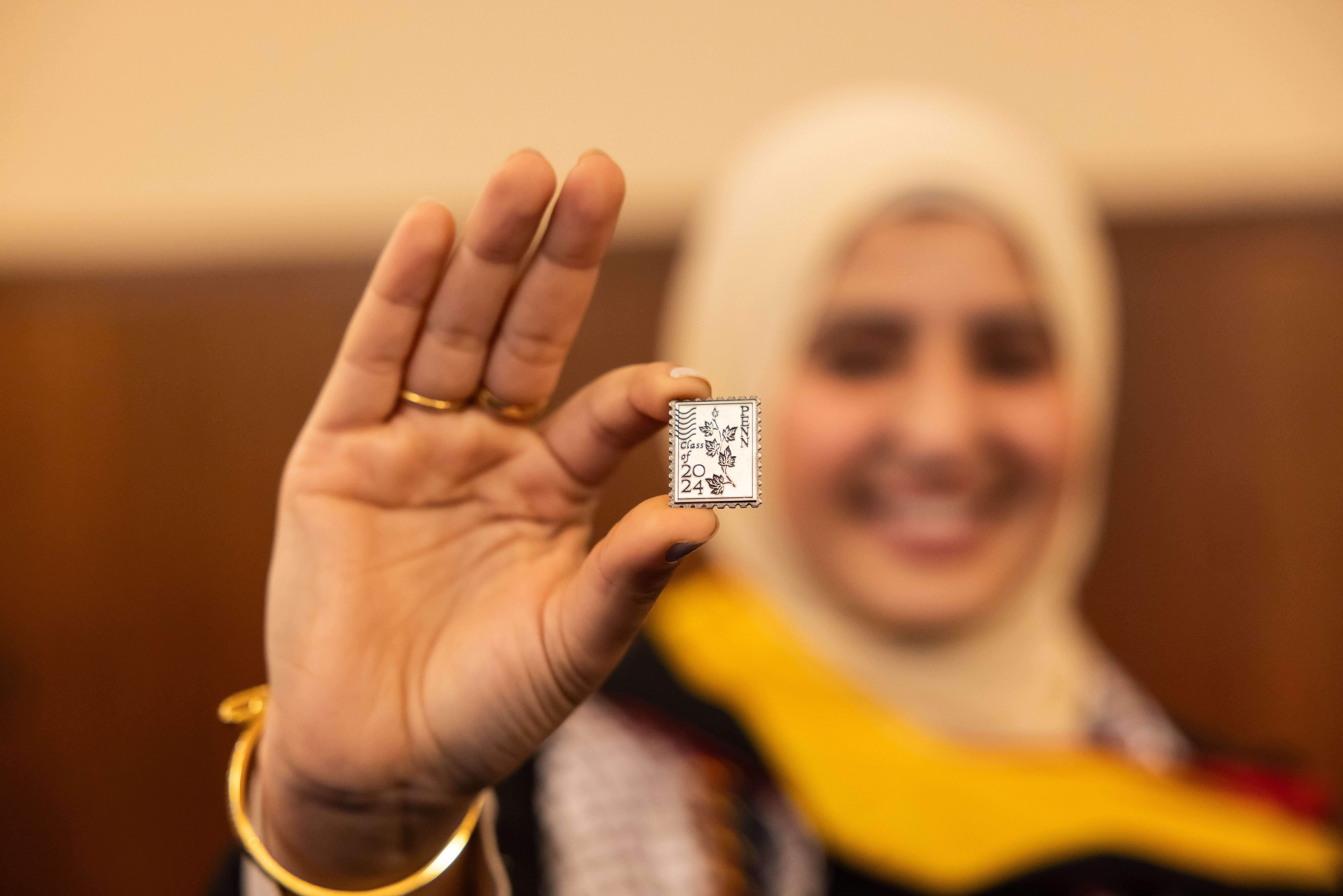 A Penn student holds up the Class of 2024 Ivy pin.