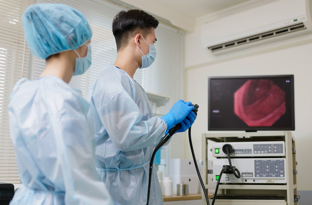 Two medical professional looking at a screen during a colonoscopy.