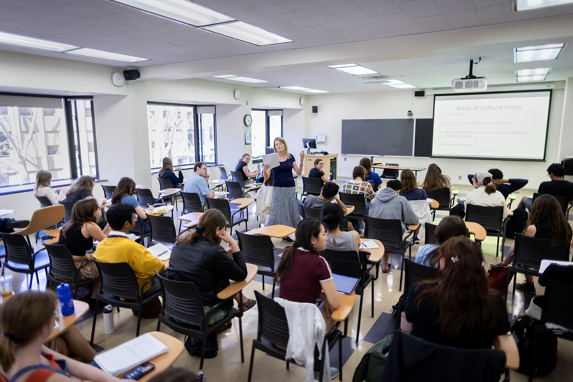 Jennifer Egan standing in middle of students sitting at desks in classroom