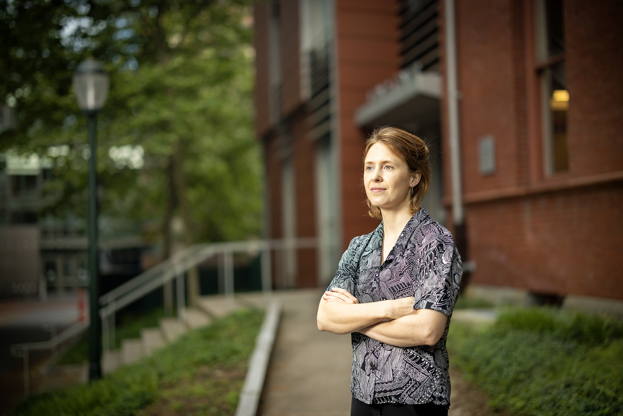 Katherine Scahill poses with her arms crossed in front of the Lerner Centeron Penn's campus.