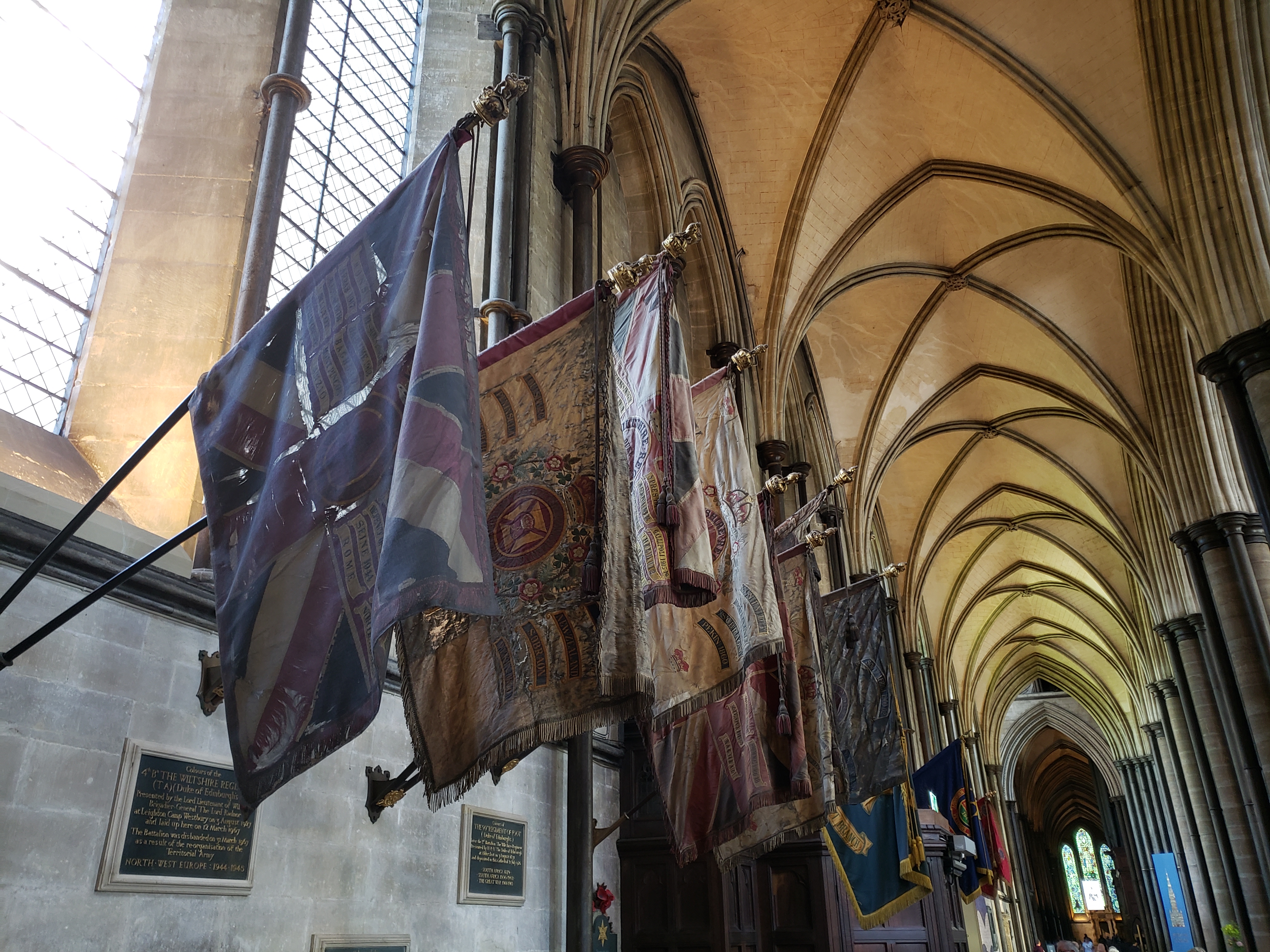 The ceiling of a large hall, with worn flags on the sides