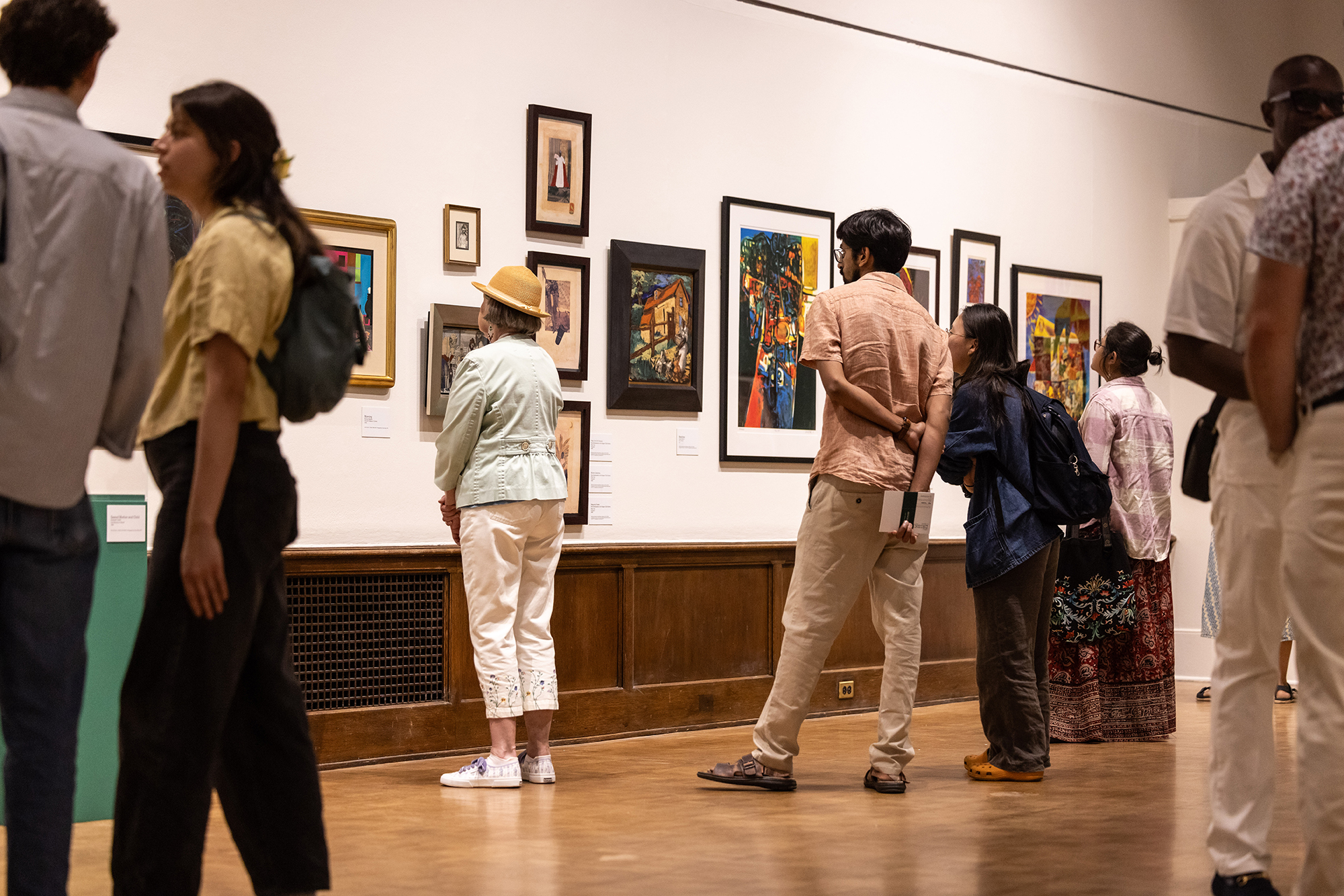 people in an art gallery looking at artworks on the wall