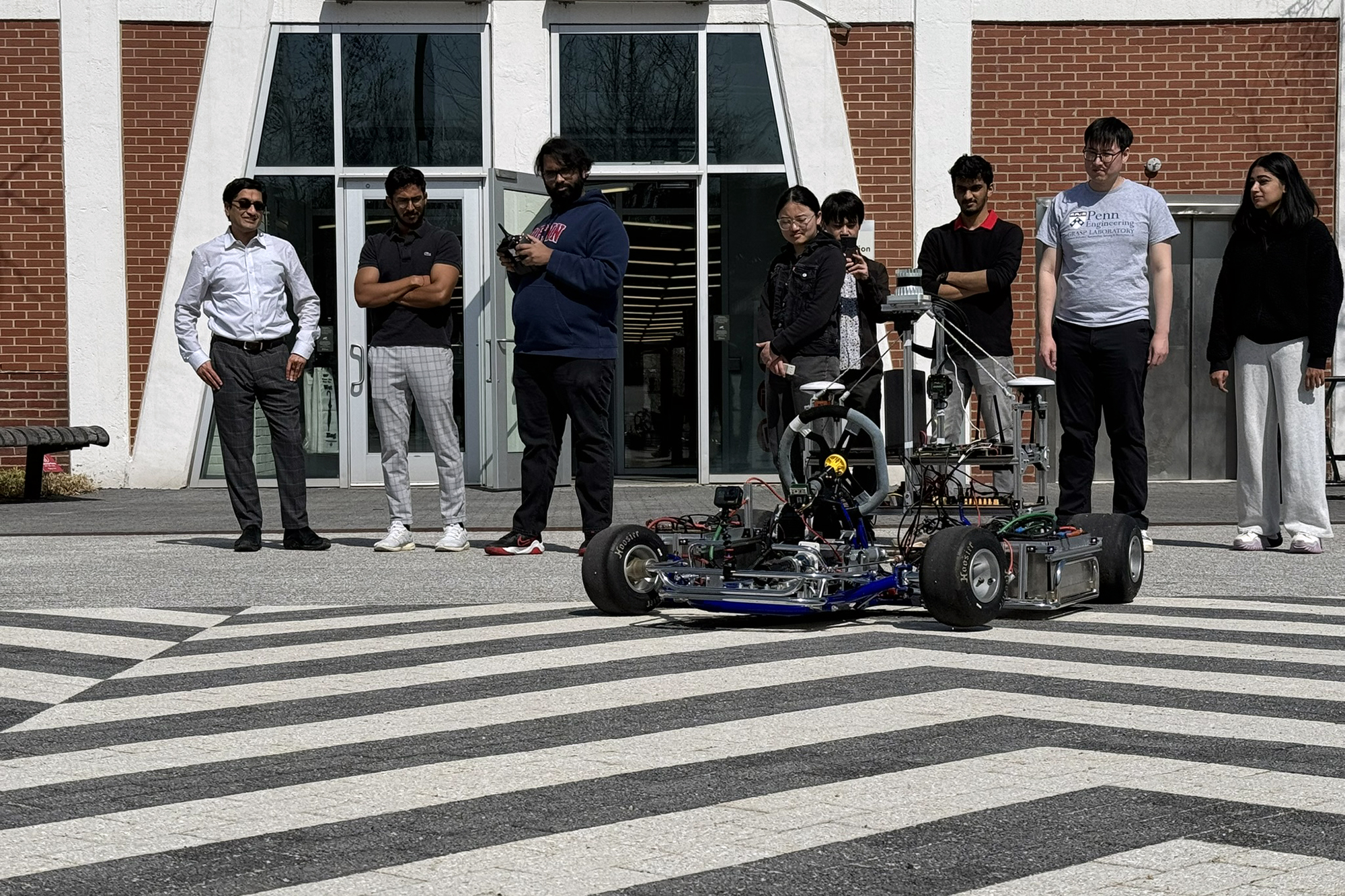 Students with a model racecar outside Pennovation.