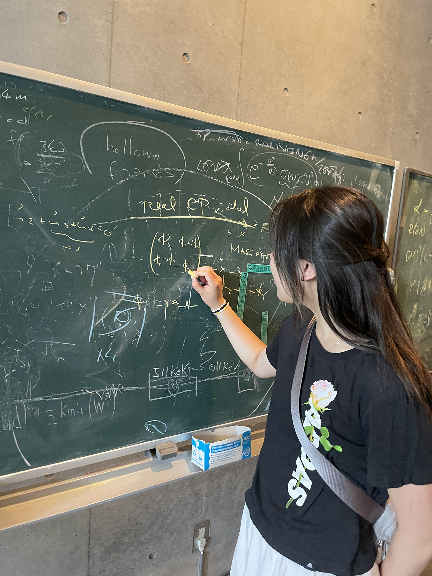 A penn student writing on a blackboard in Japan.